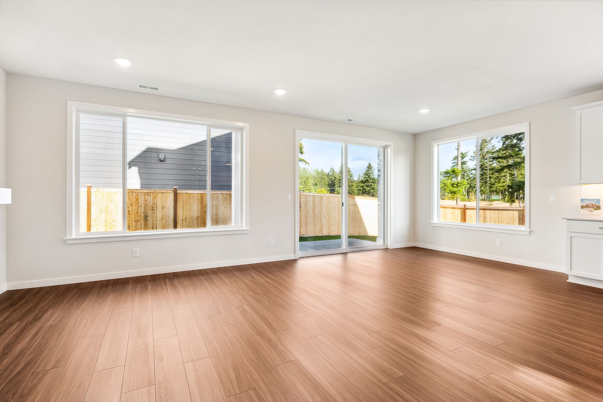 A room with a wood floor and windows.