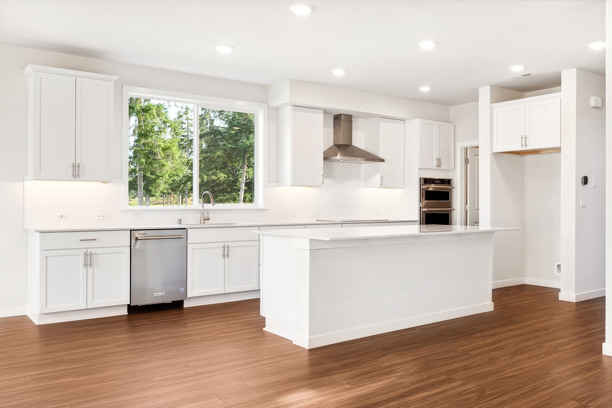 A kitchen with white cabinets.