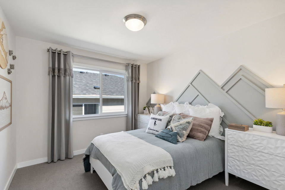 A bedroom with a bed and a window.