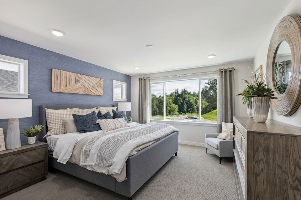 A bedroom with a large window.