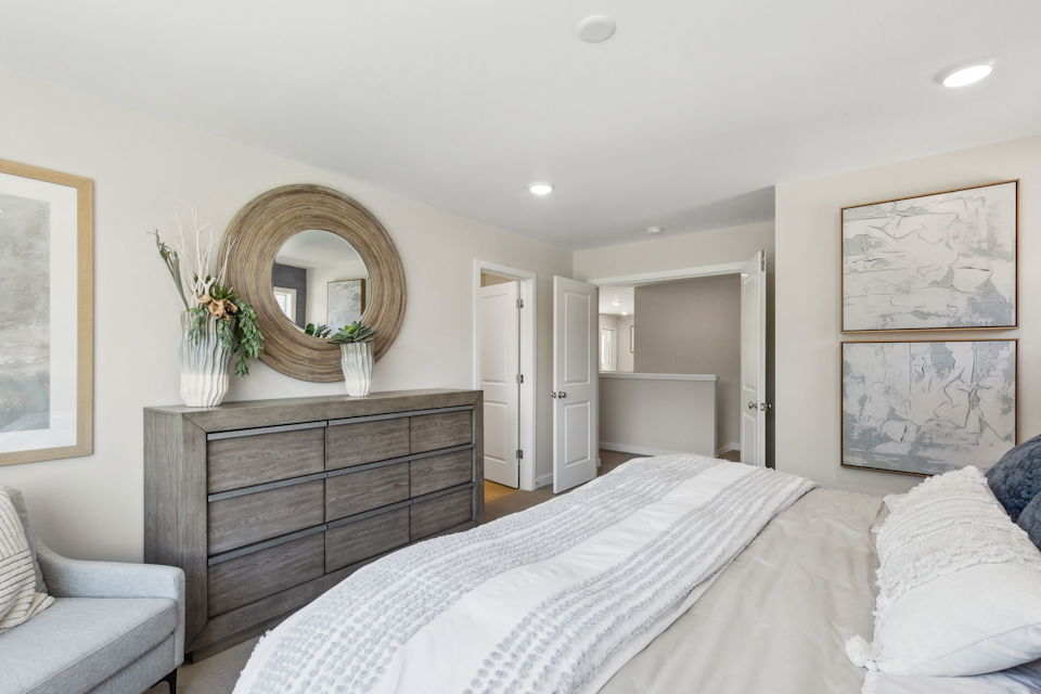 A bedroom with a bed and a mirror.