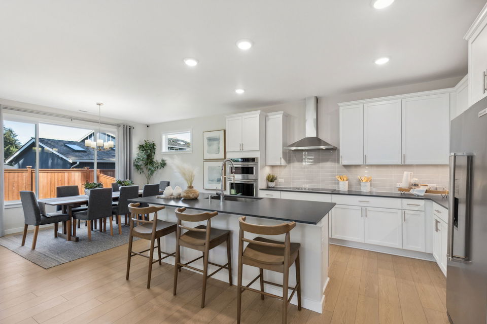 A kitchen with a dining table and chairs.