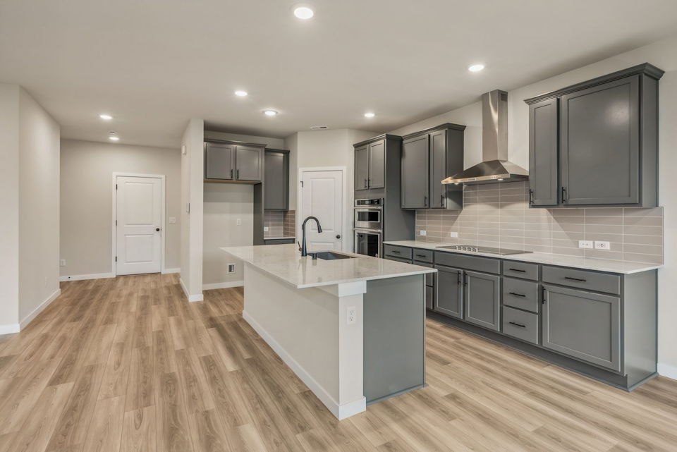 A kitchen with black cabinets.