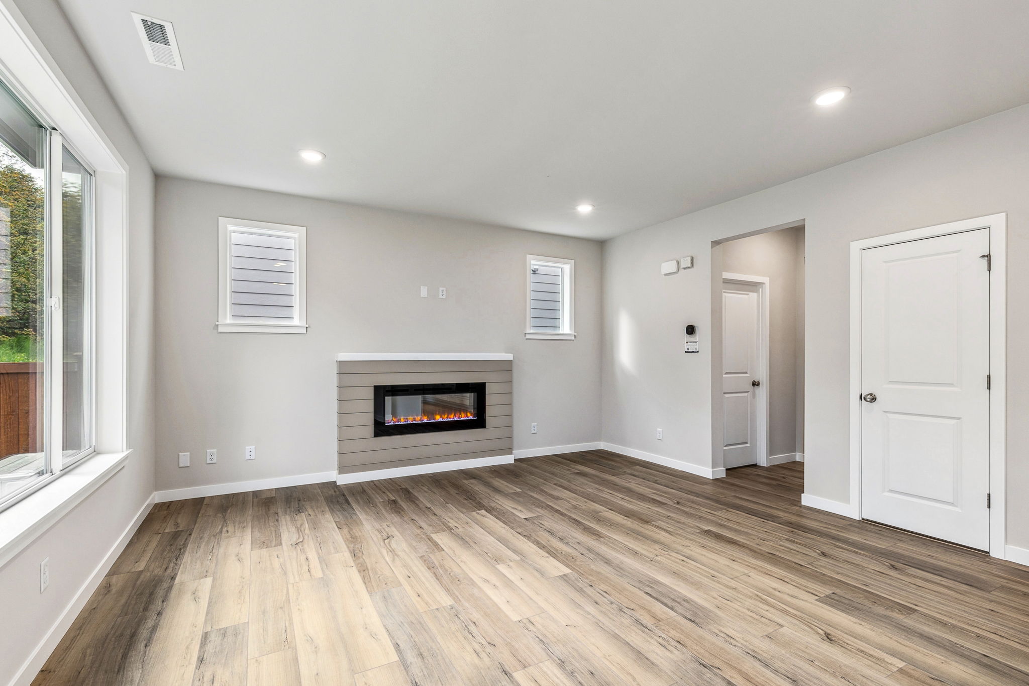 A room with a fireplace and a wood floor.