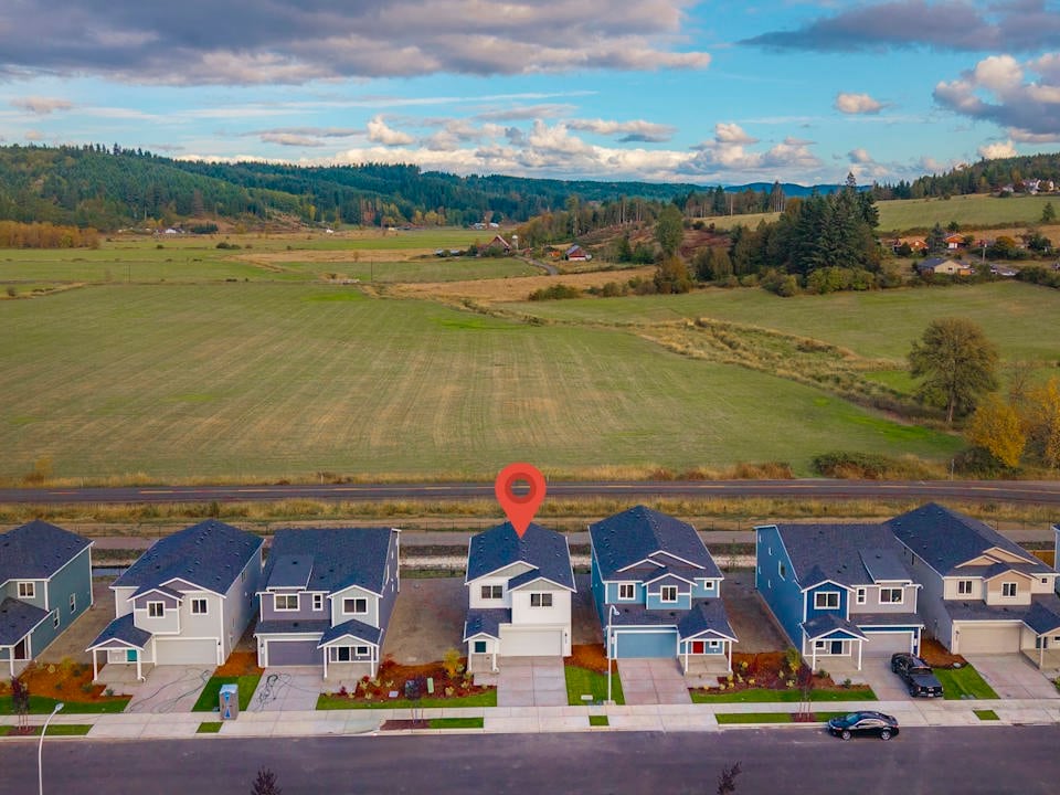 A group of houses with a large field in the background.