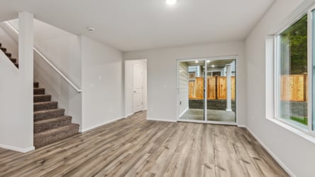A room with a wood floor and windows.