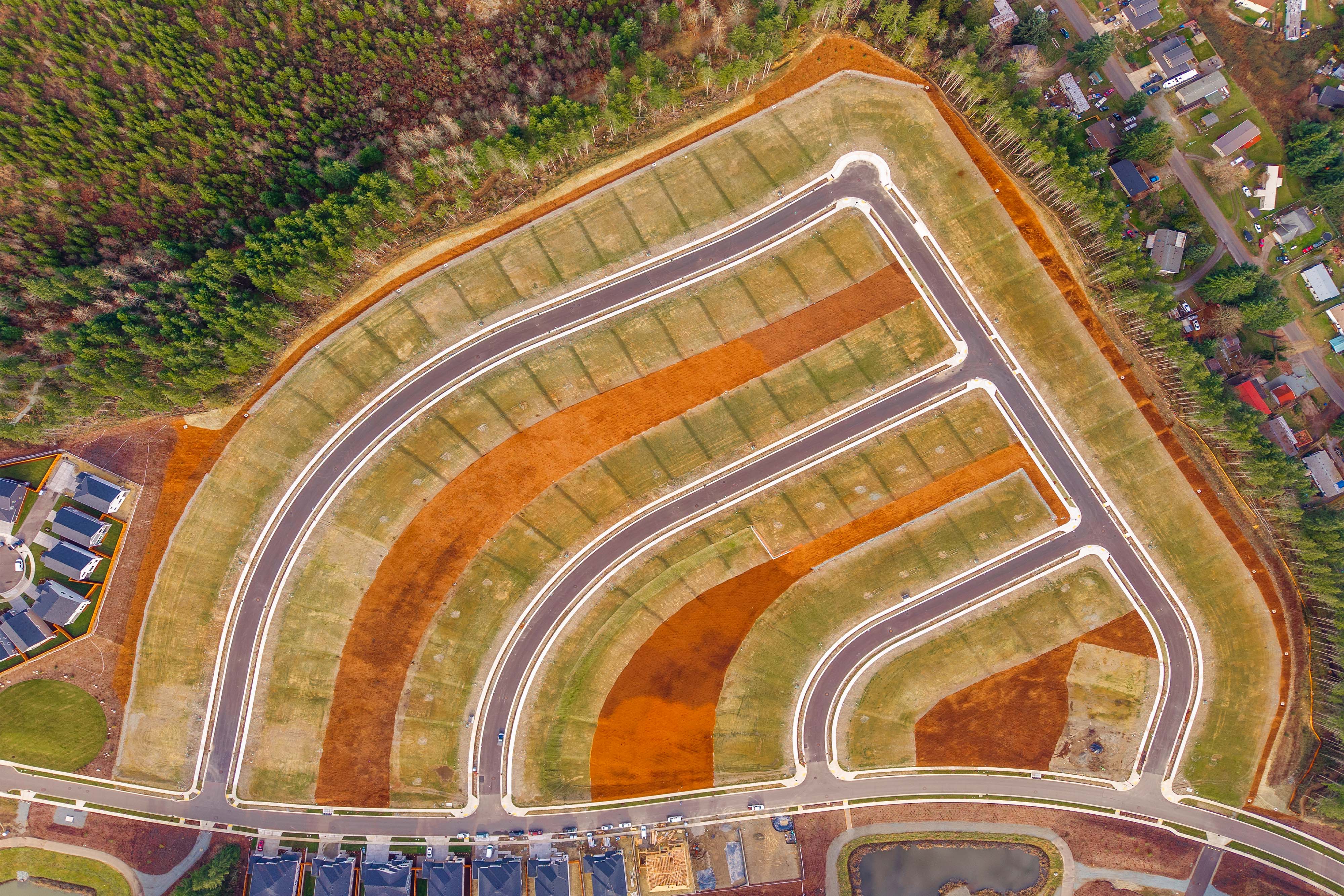 A large stadium with a field and trees around it.