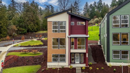 A house with a lawn and trees in the back.