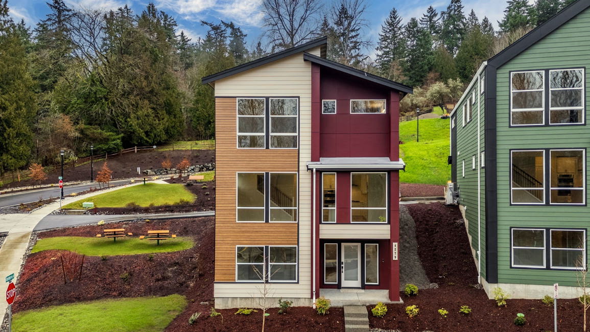 A house with a lawn and trees in the back.