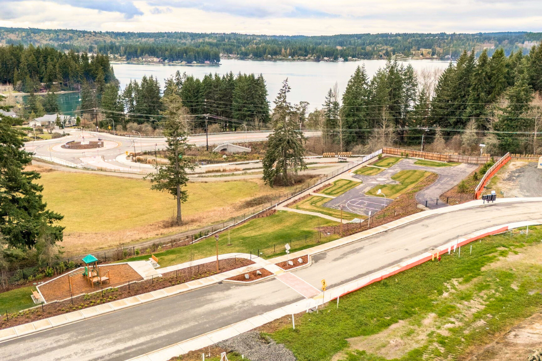 A road with a water way and trees on the side.