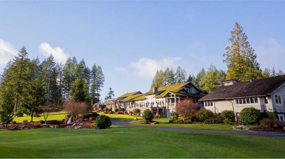 A large house with a lawn and trees in the front.