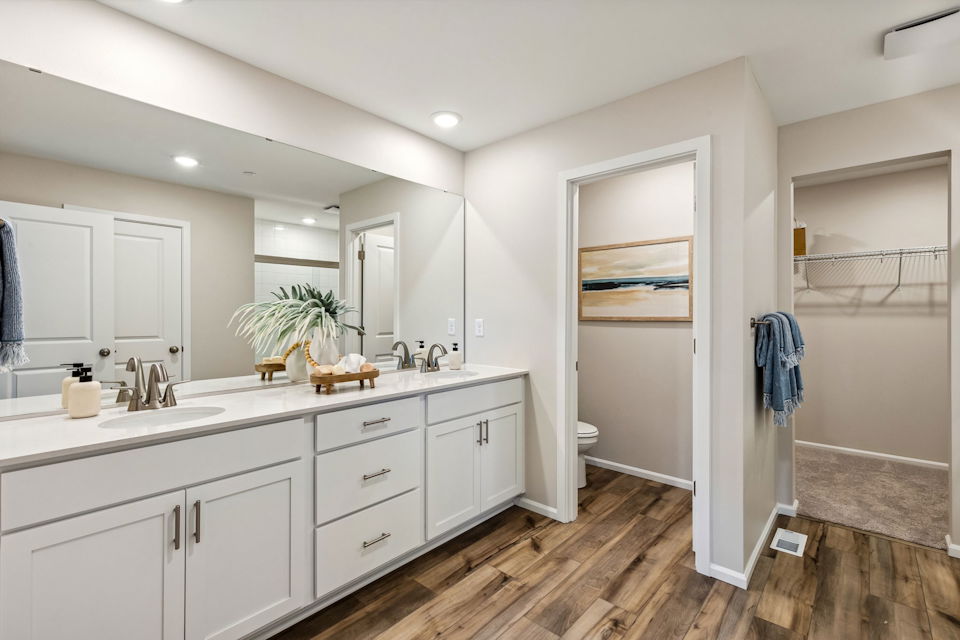 A bathroom with white cabinets.