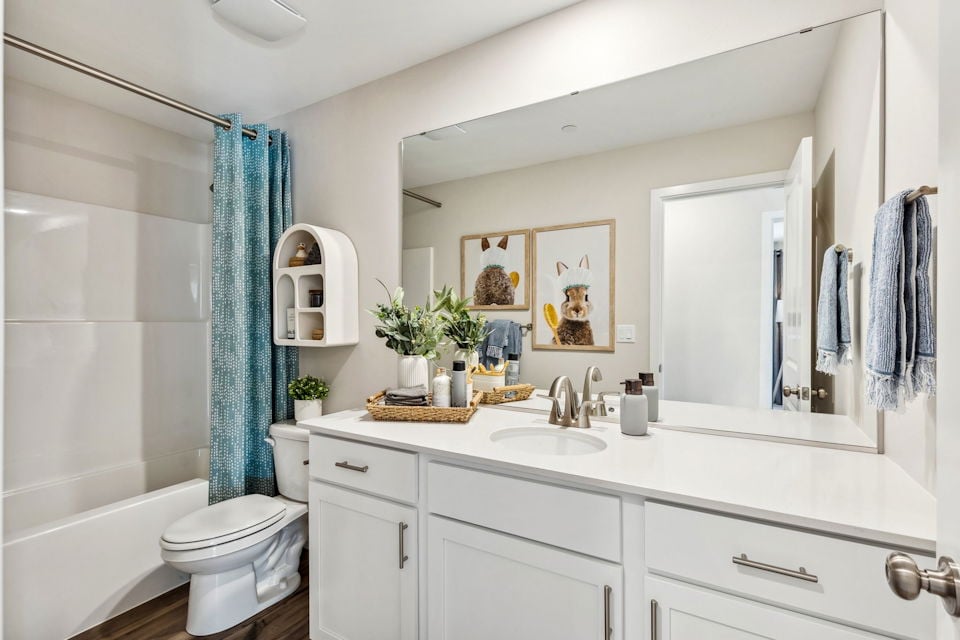 A bathroom with a tub sink and toilet.