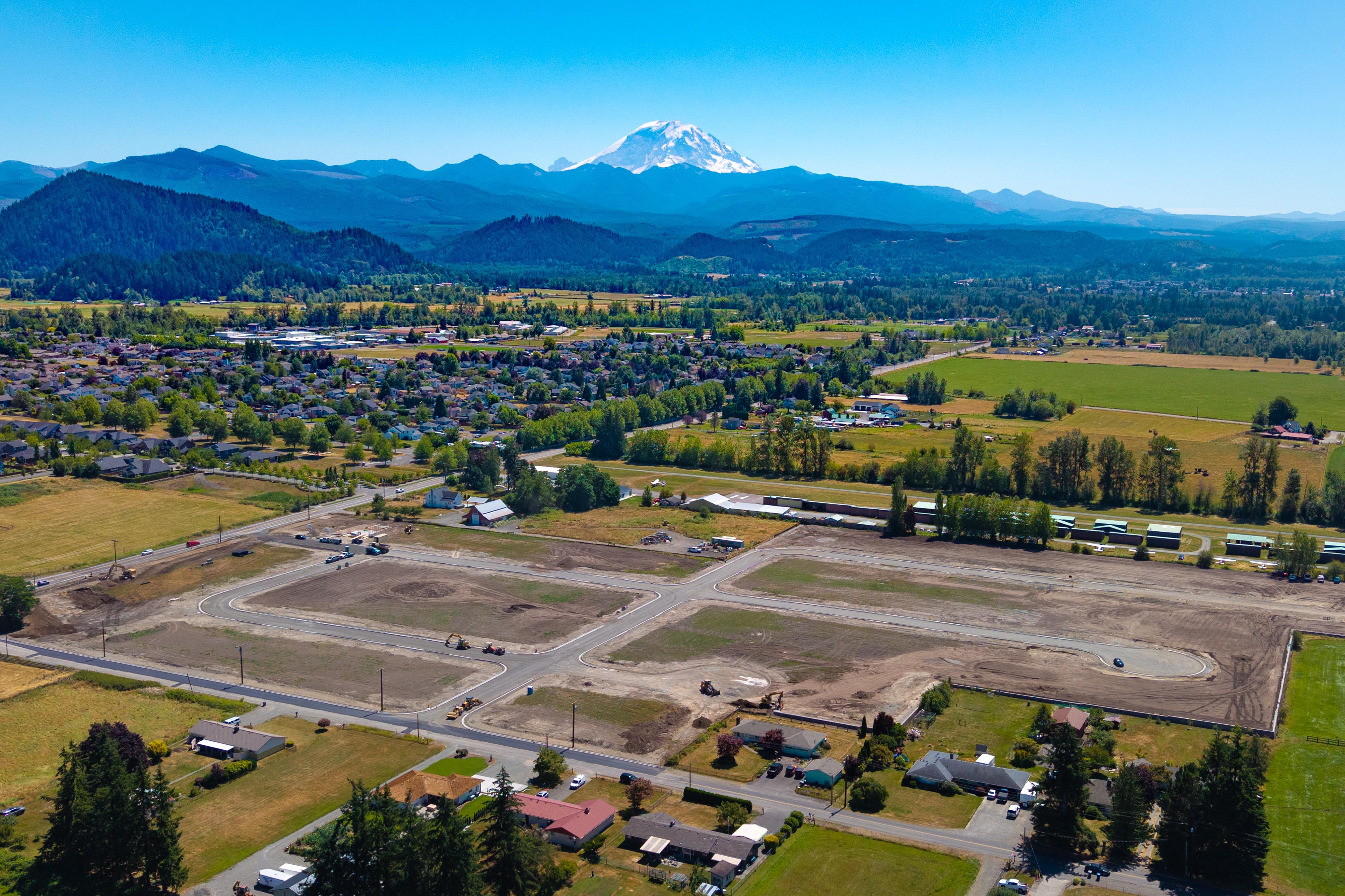 A large empty parking lot with a mountain in the background.