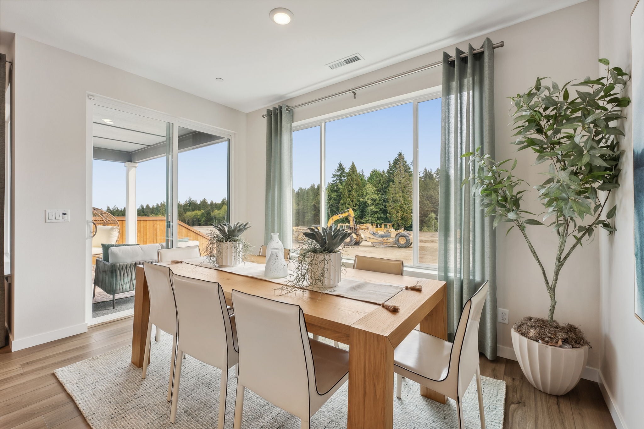 A dining room table with chairs and a large window.