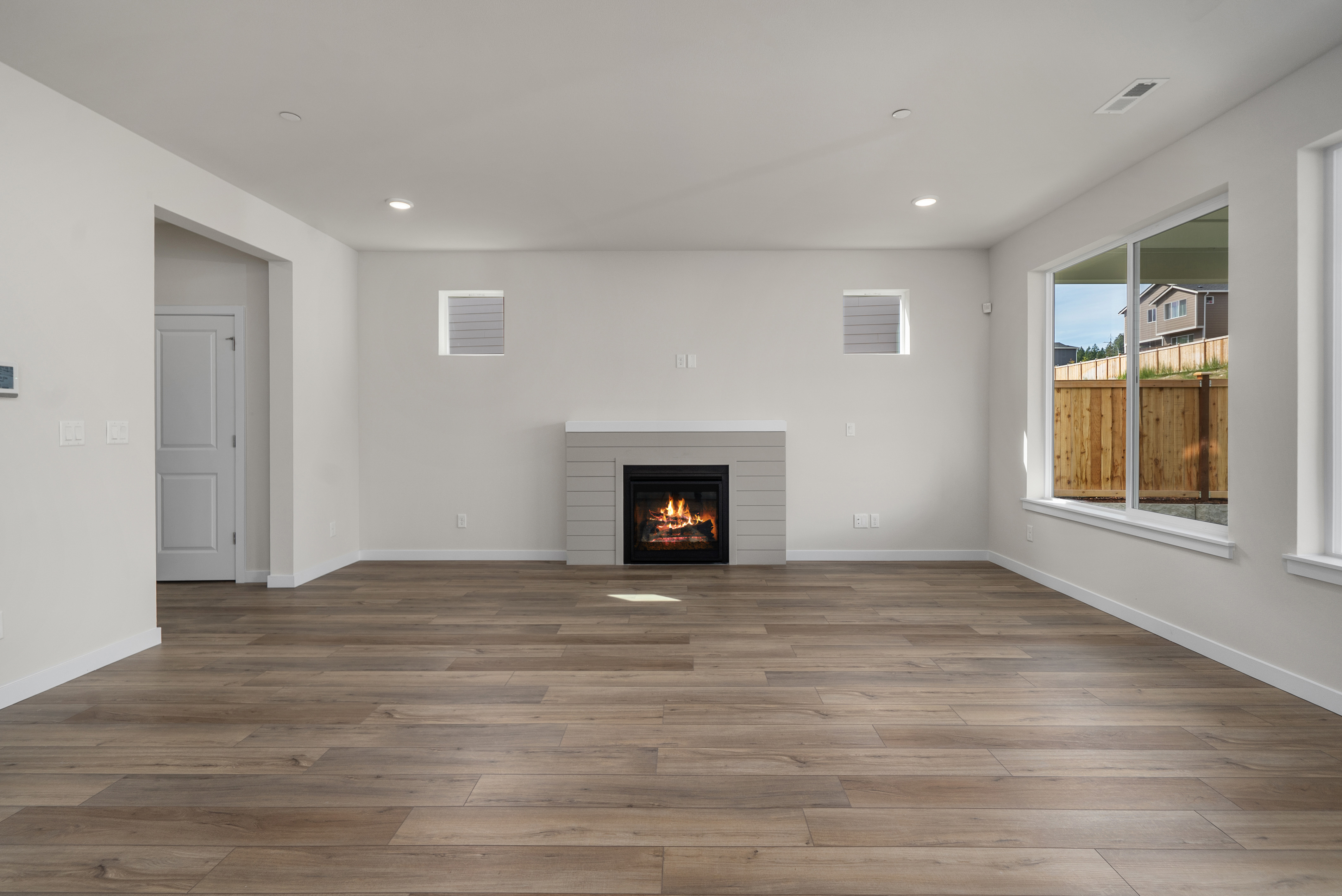 A room with a fireplace and a wood floor.