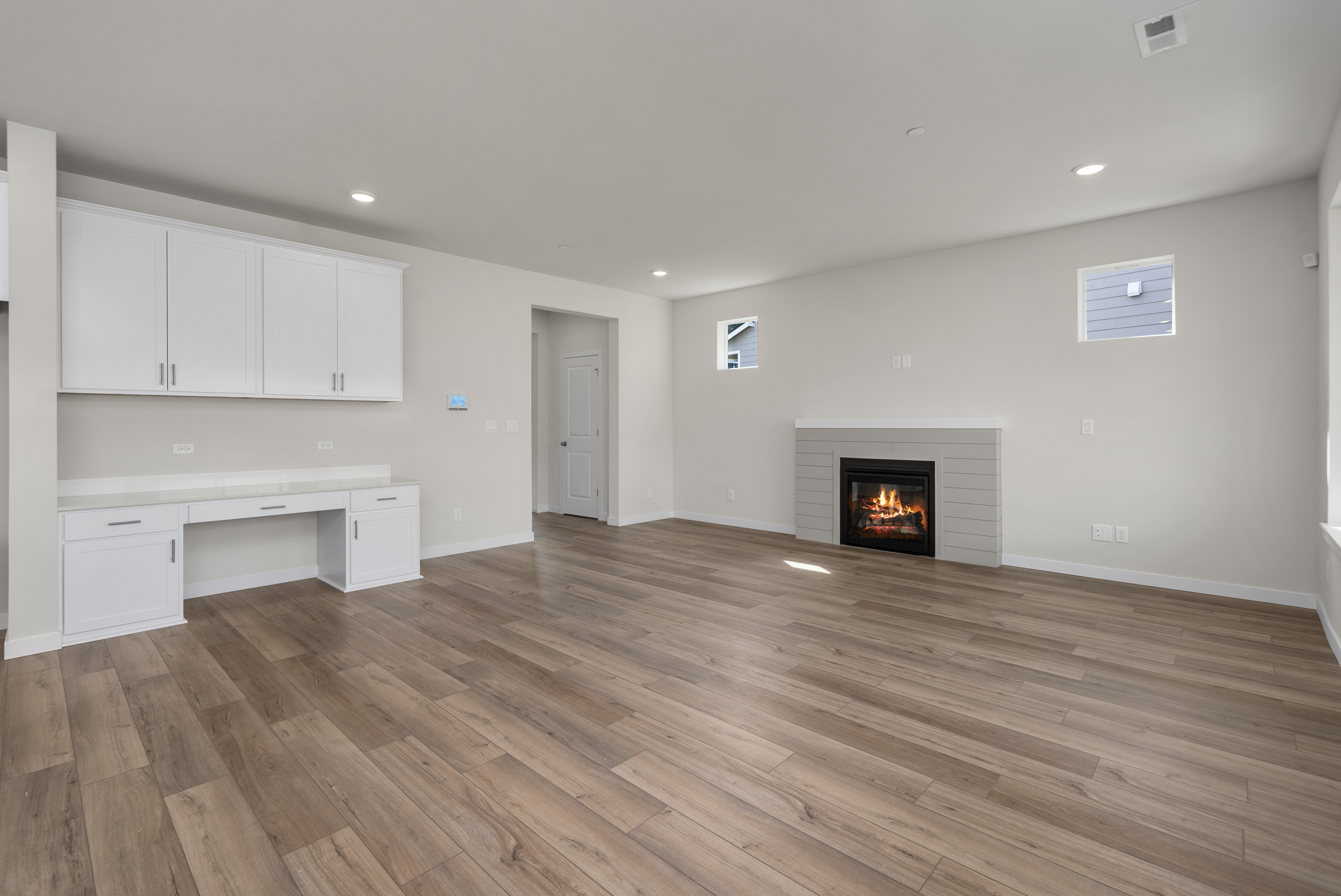 A room with a fireplace and white cabinets.