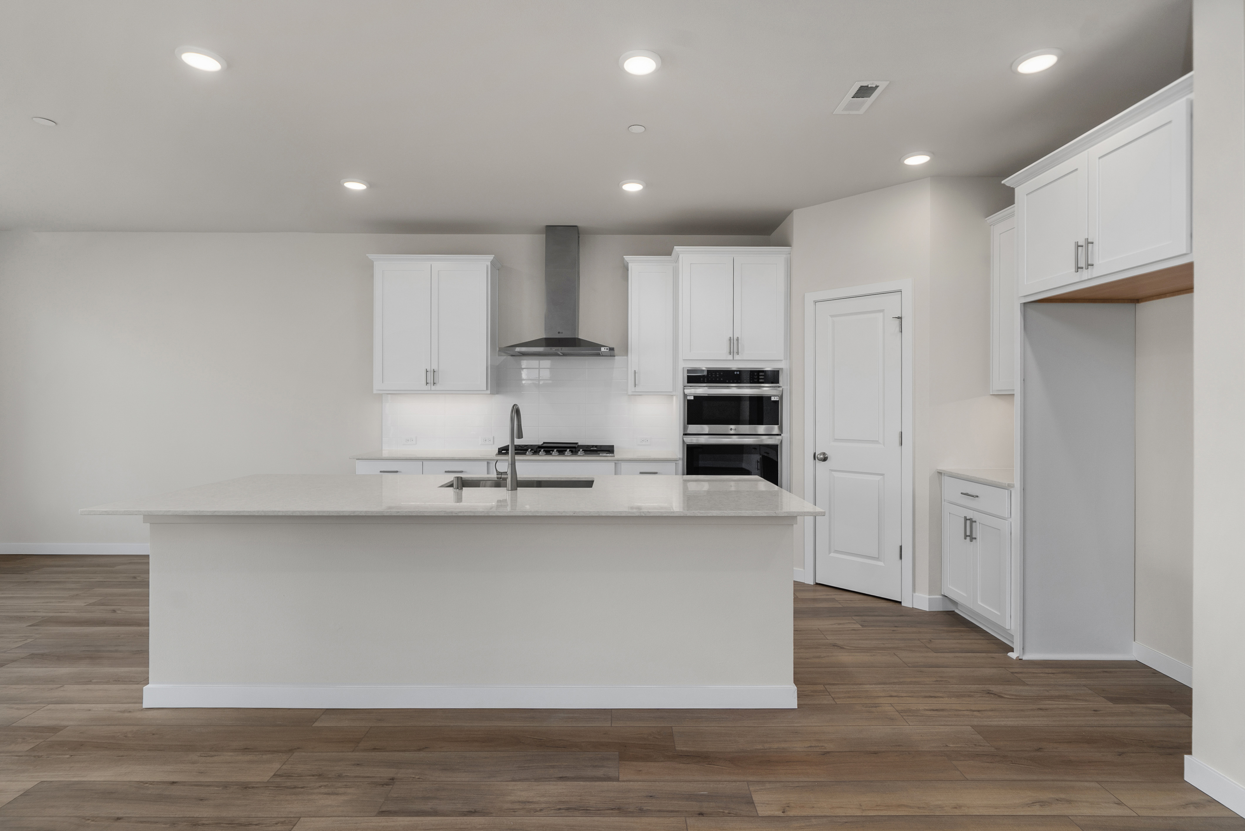 A kitchen with white cabinets.