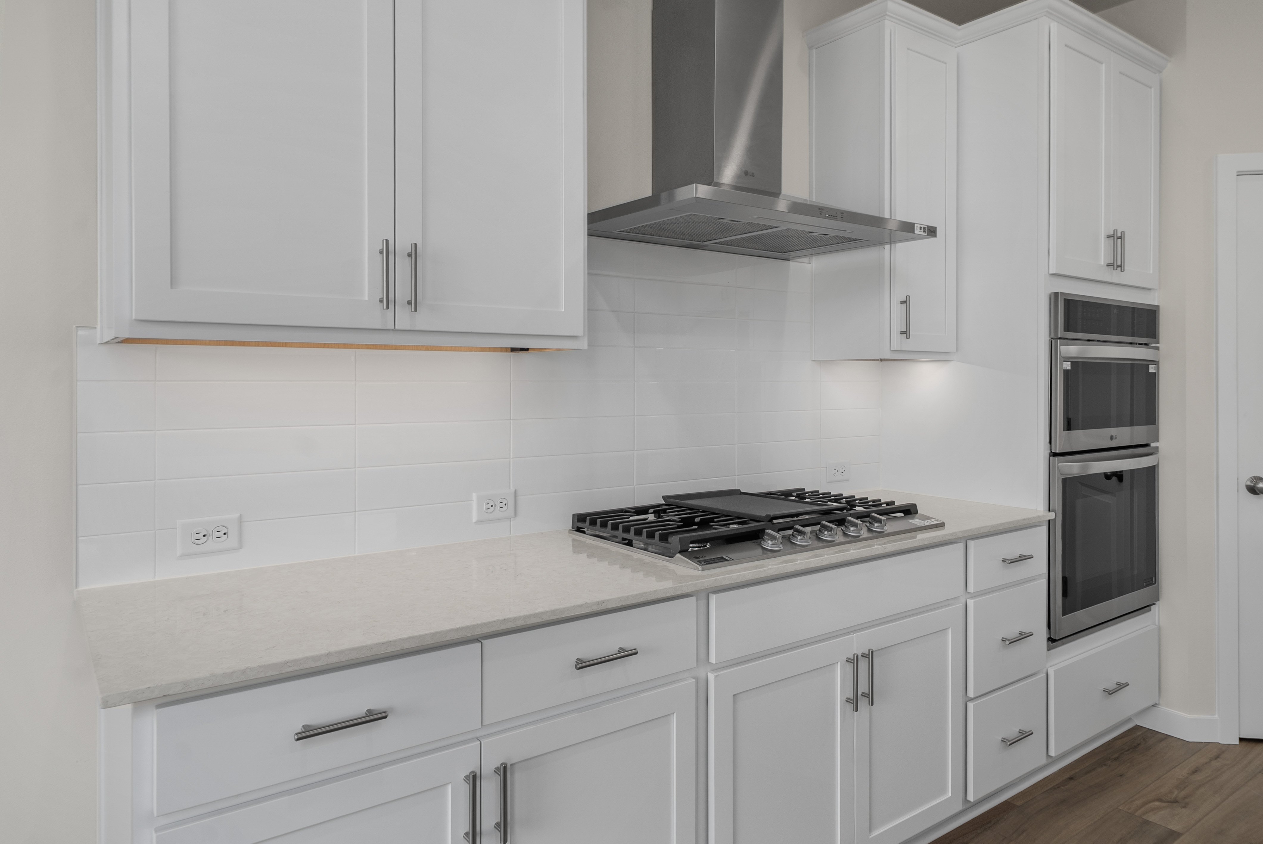 A kitchen with white cabinets.