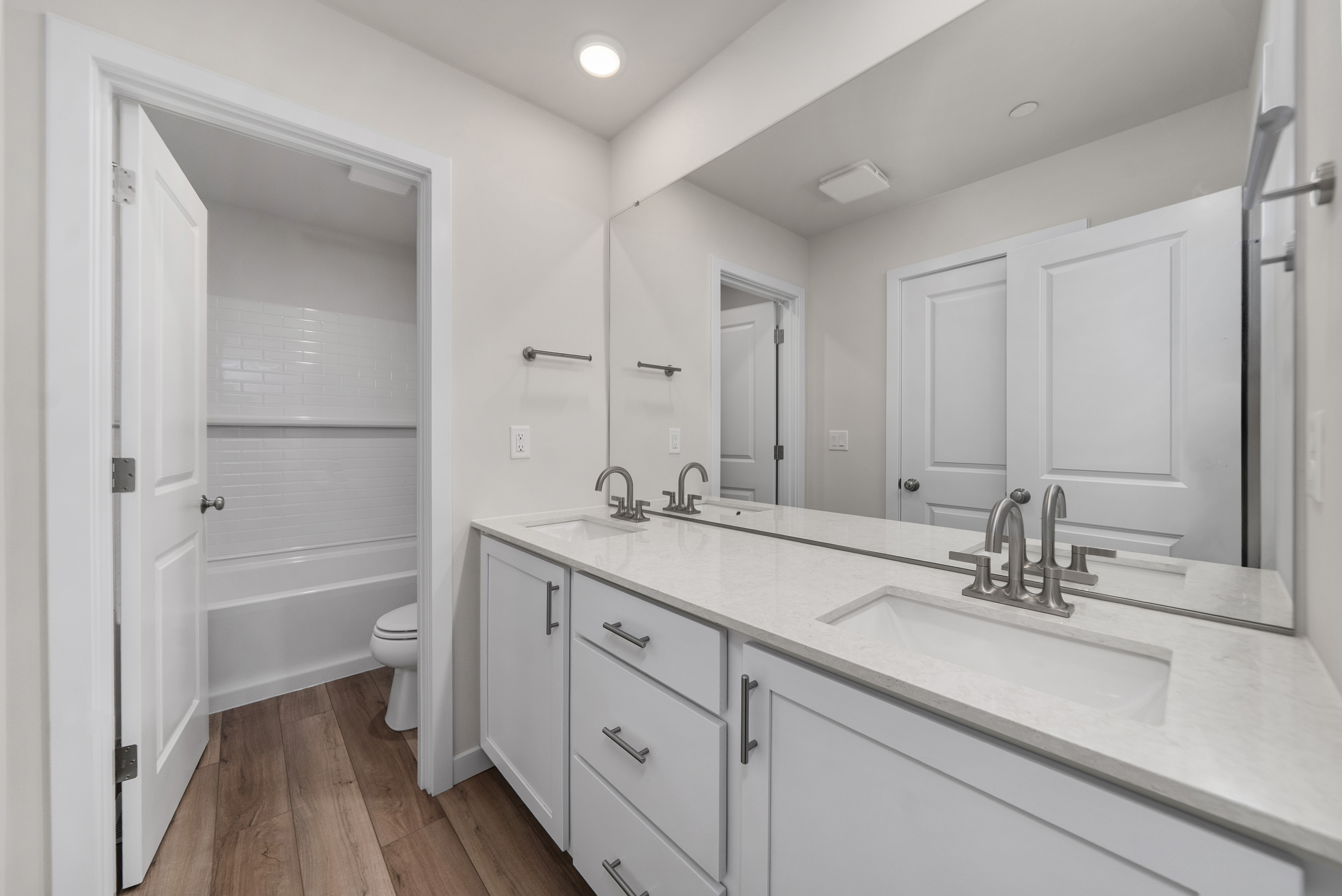 A bathroom with white cabinets.