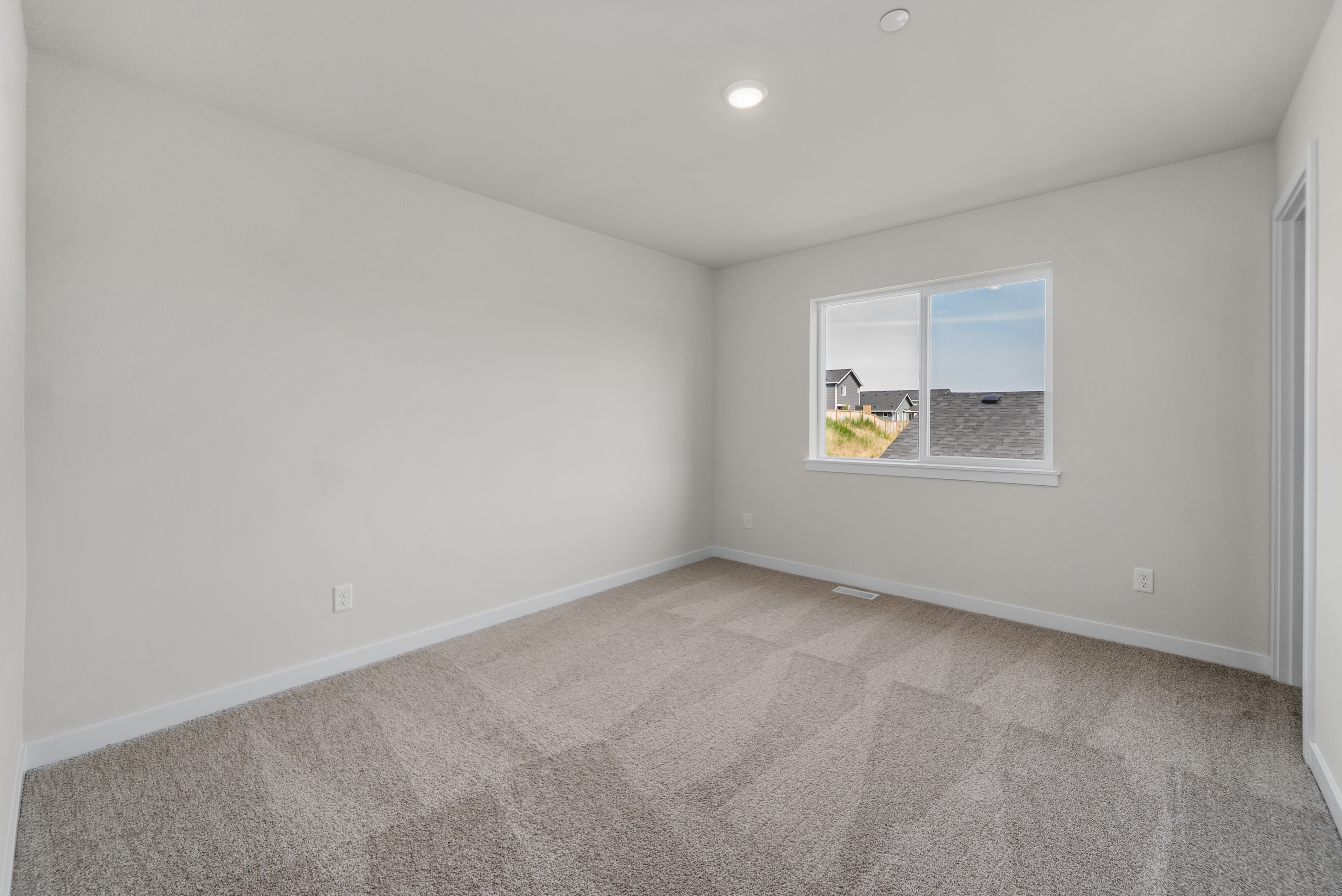 A room with a carpet and a window.