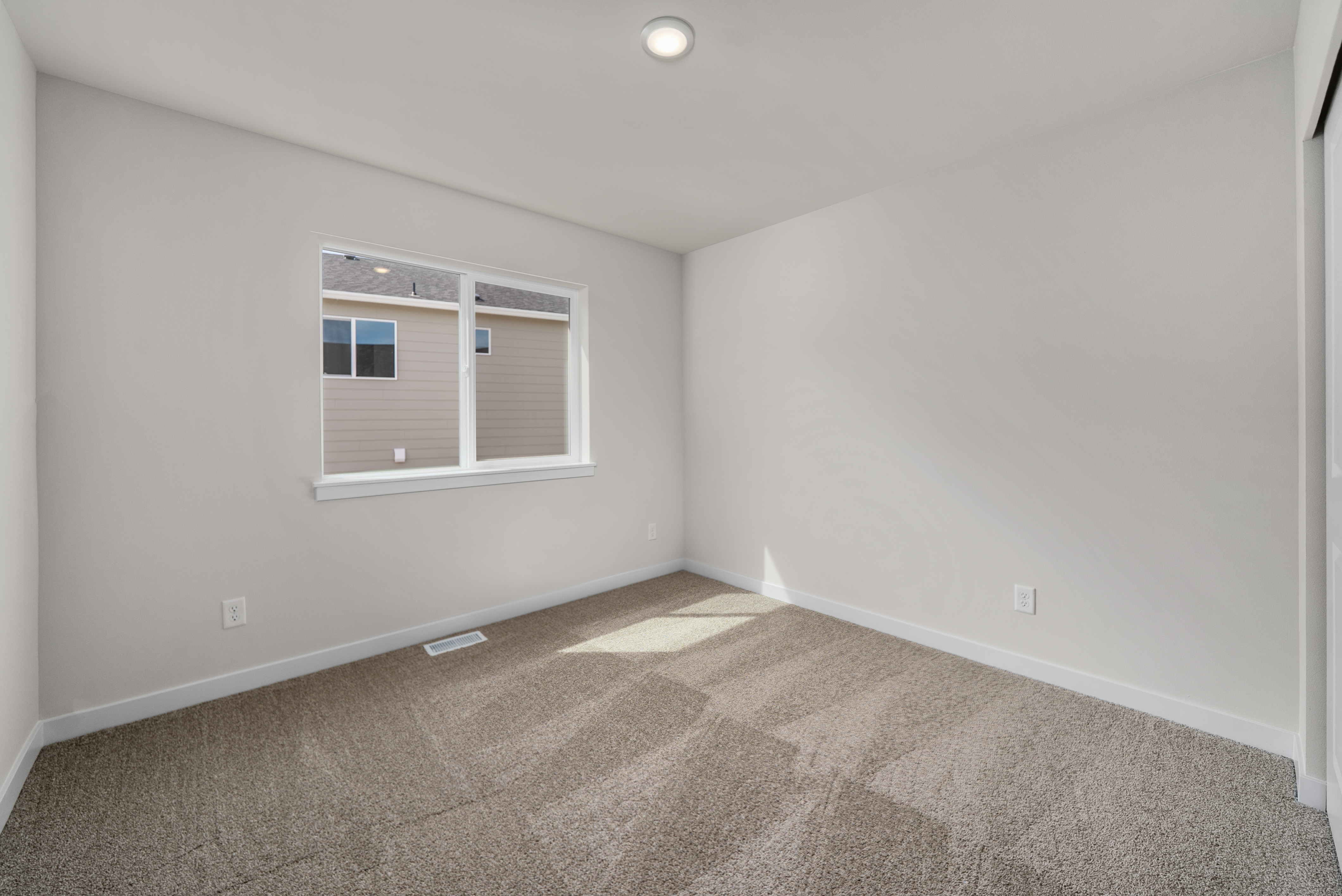 A room with a carpet and a window.
