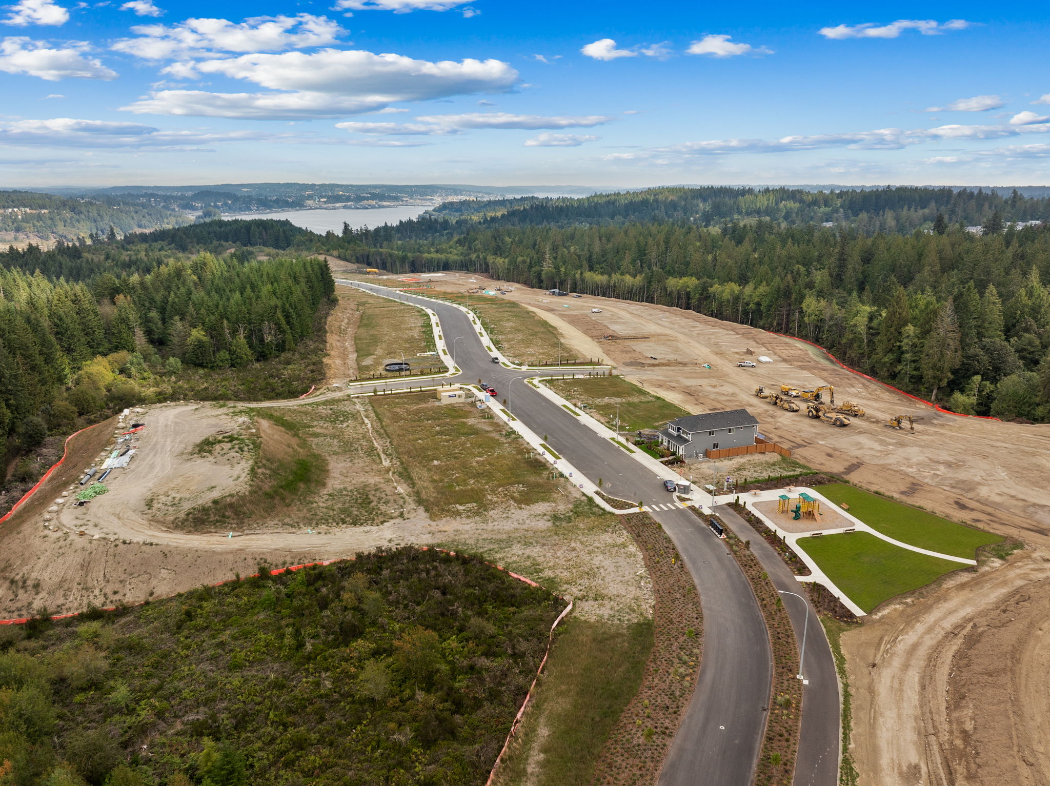 A road with a few cars on it and trees around it.