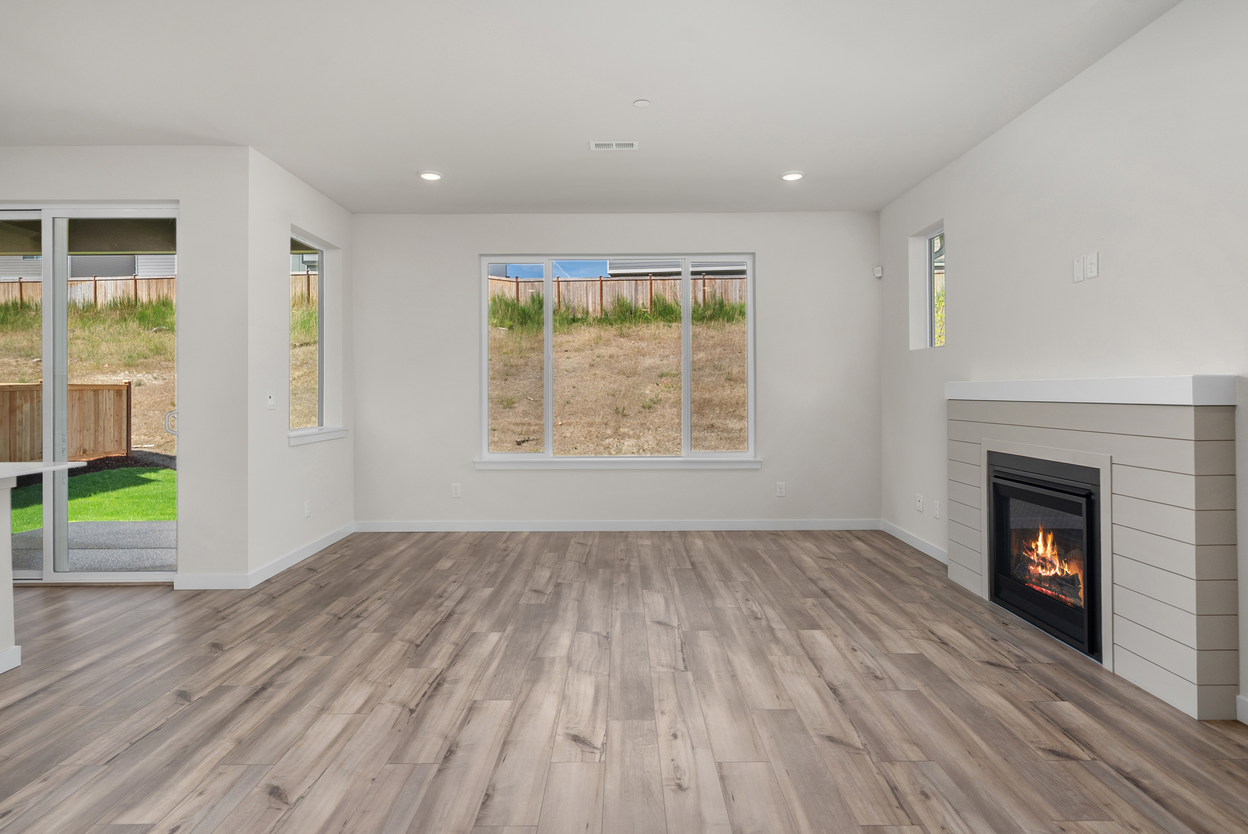A room with a fireplace and a wood floor.