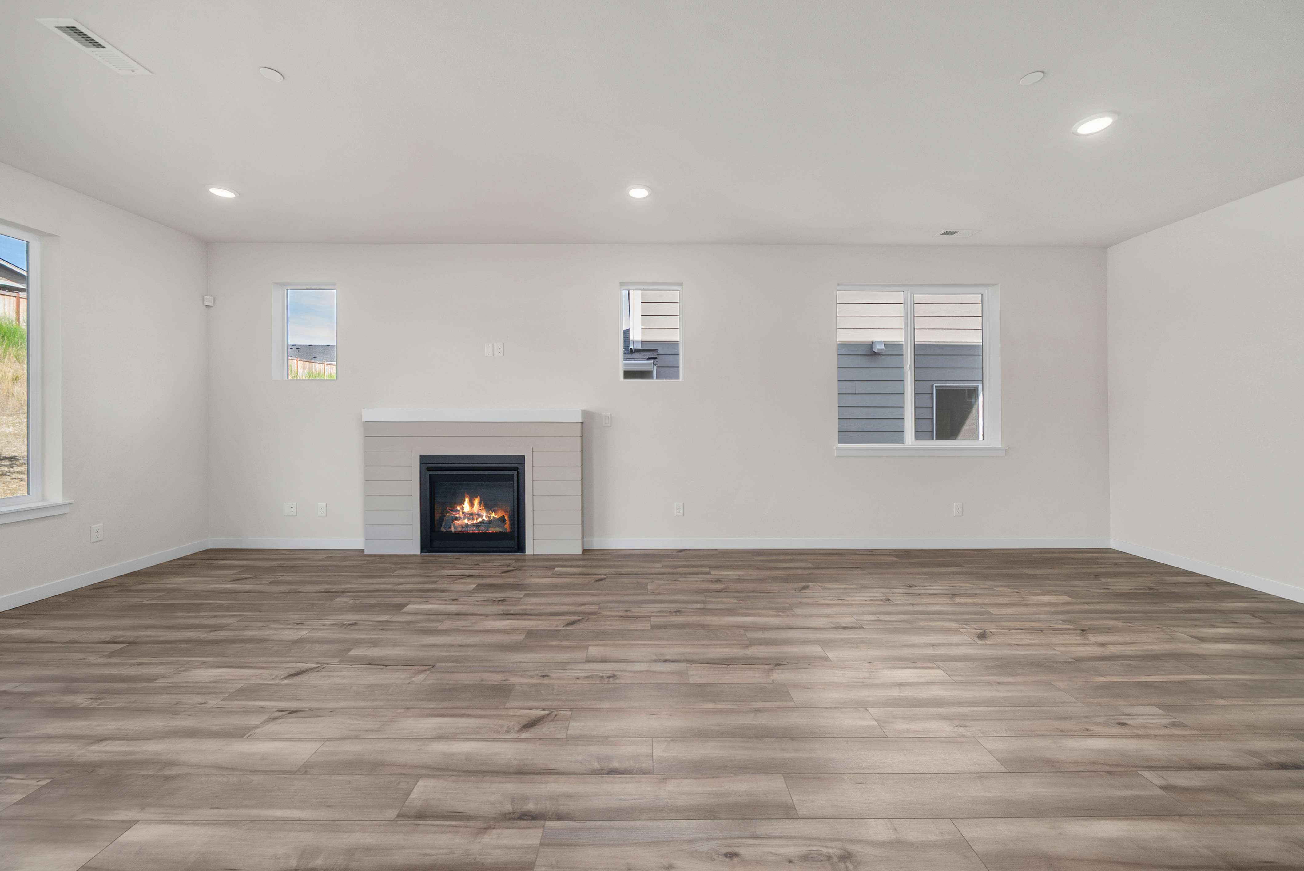 A room with a fireplace and a wood floor.