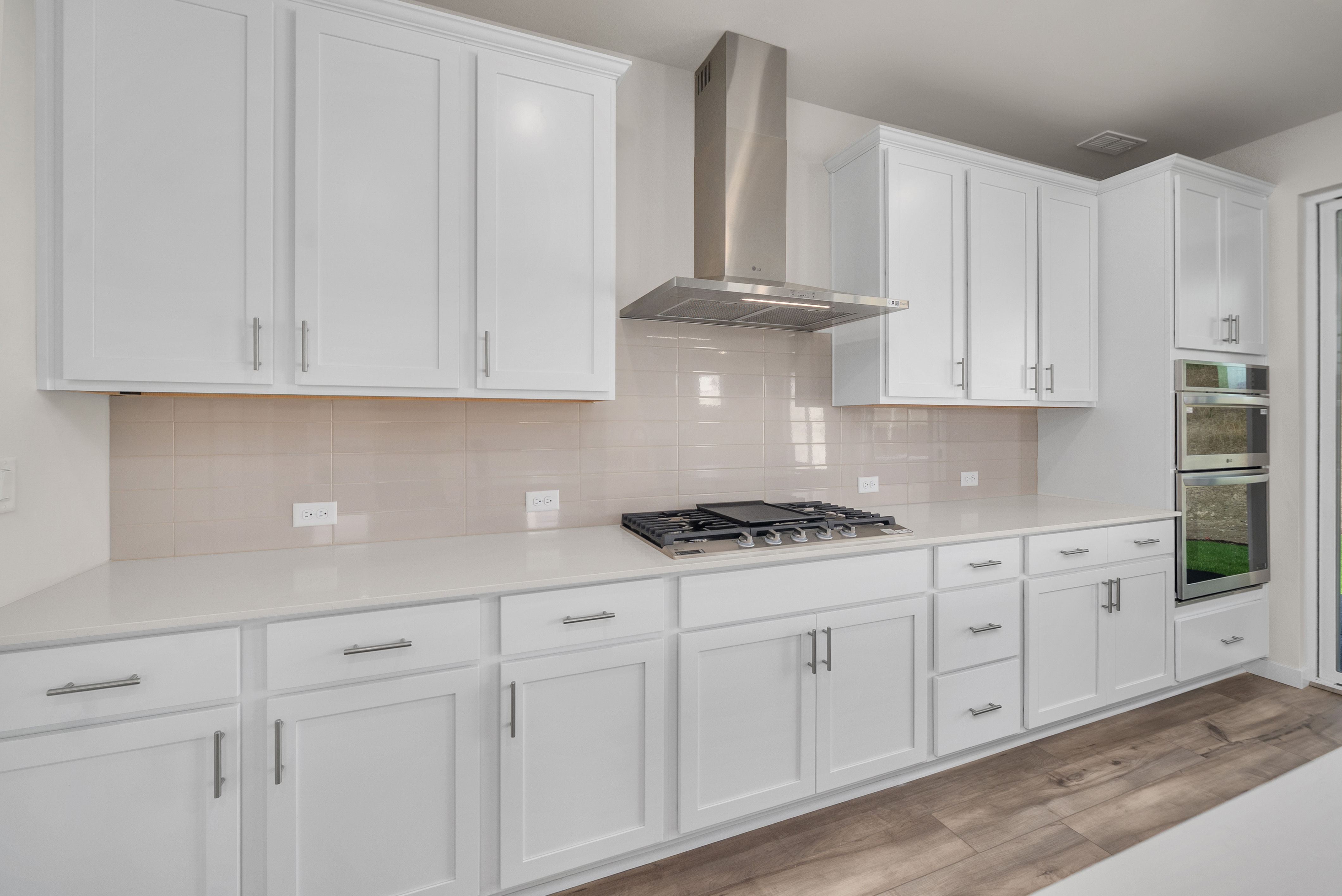 A kitchen with white cabinets.
