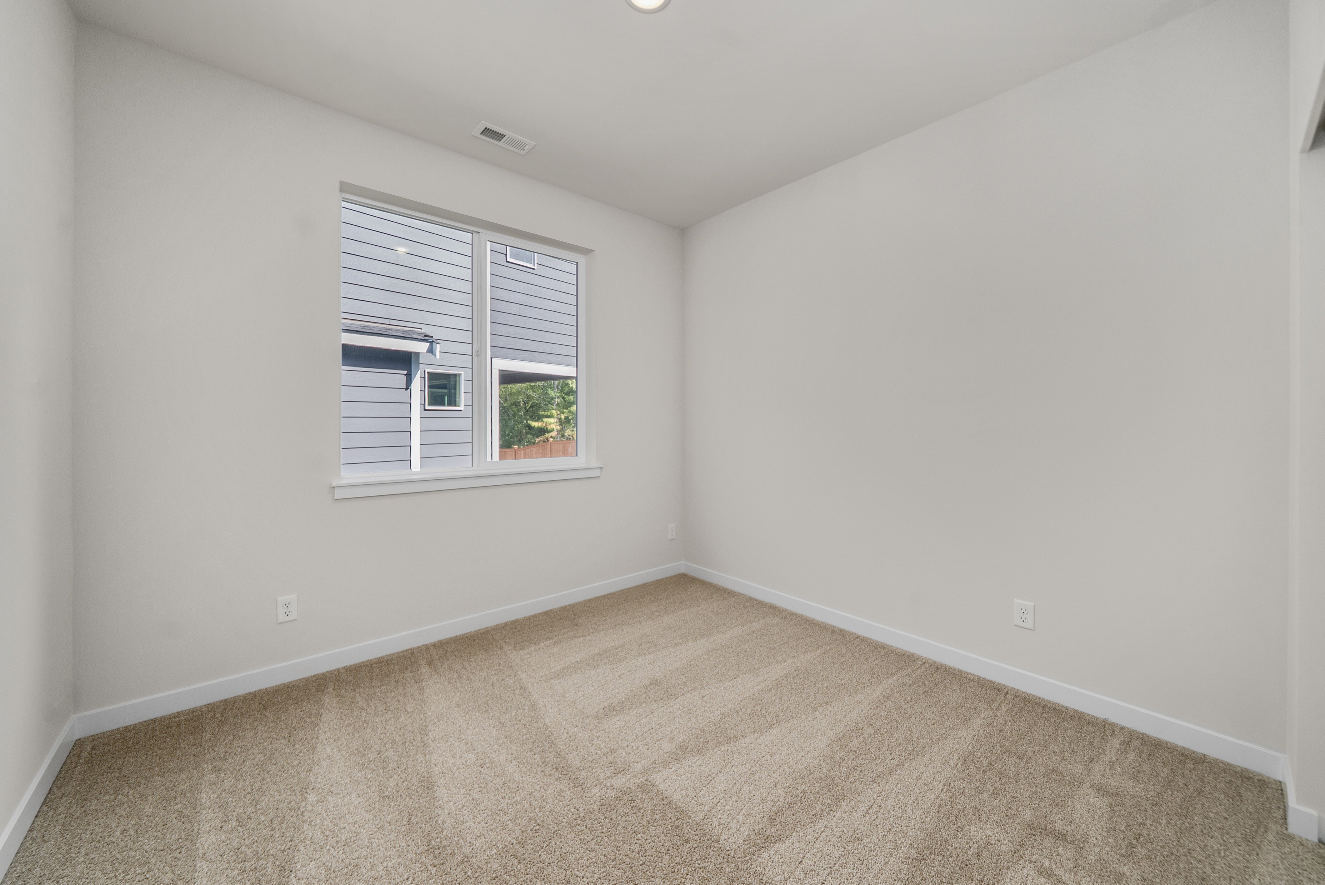 A room with a window and a carpet.