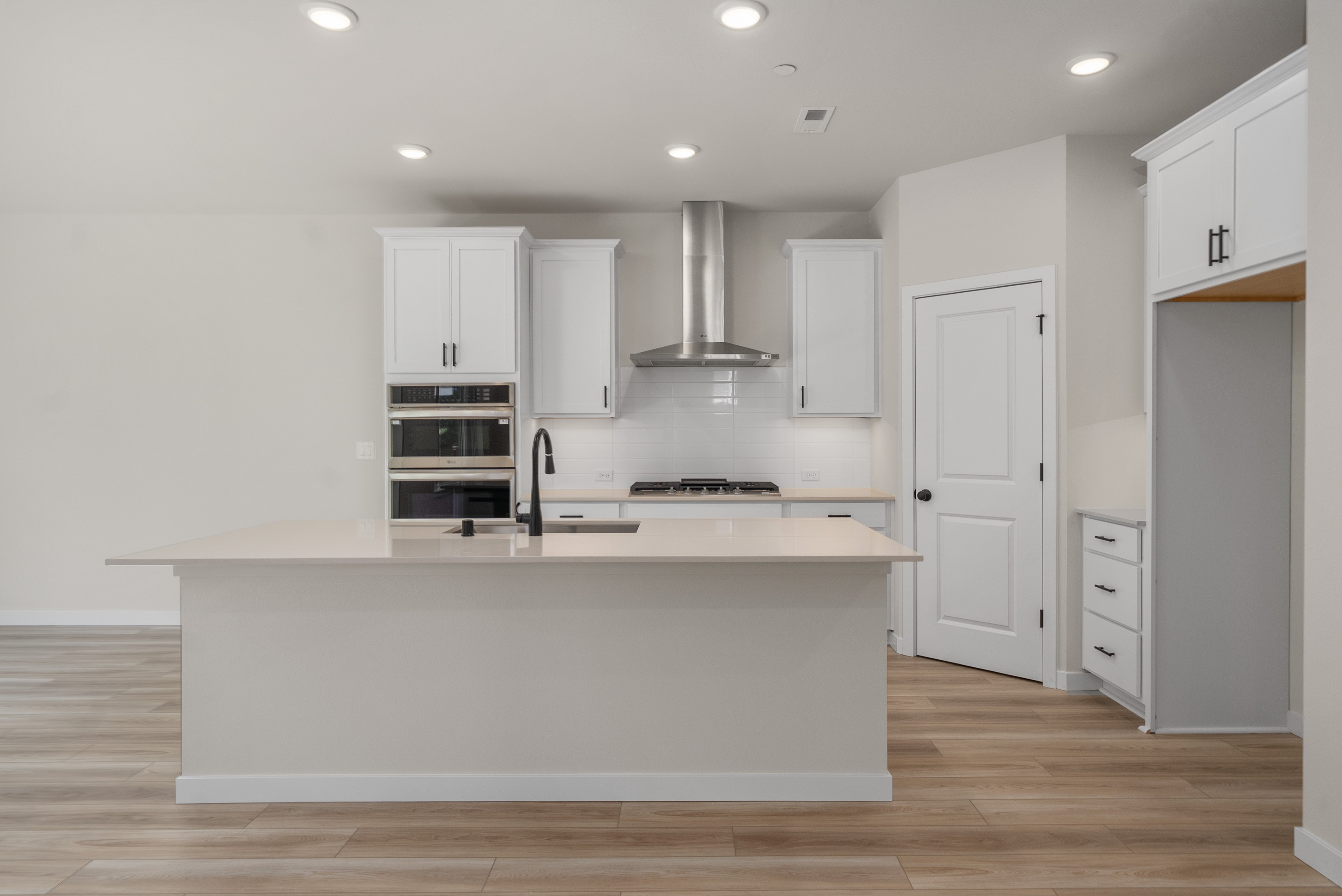 A kitchen with white cabinets.