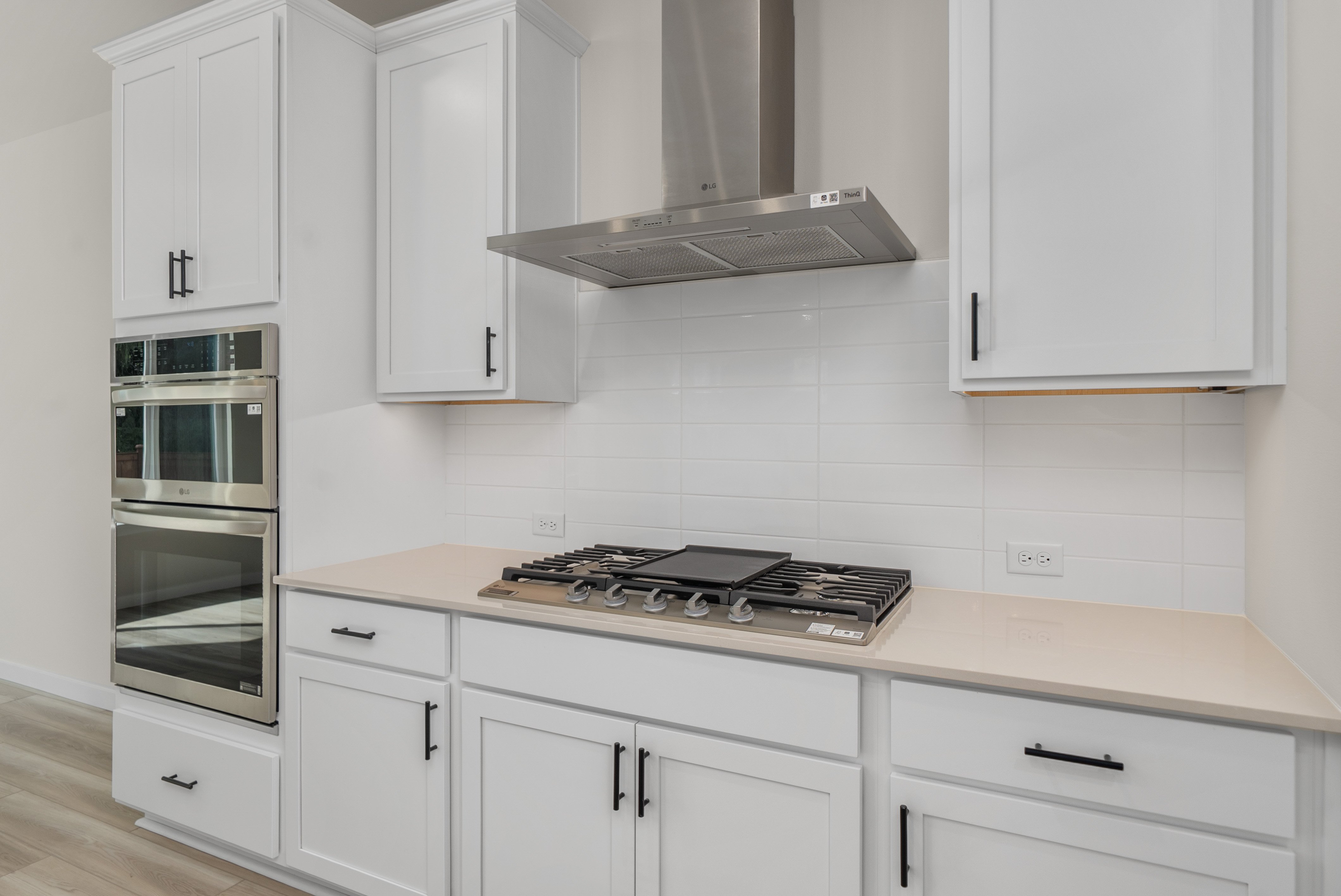 A kitchen with white cabinets.
