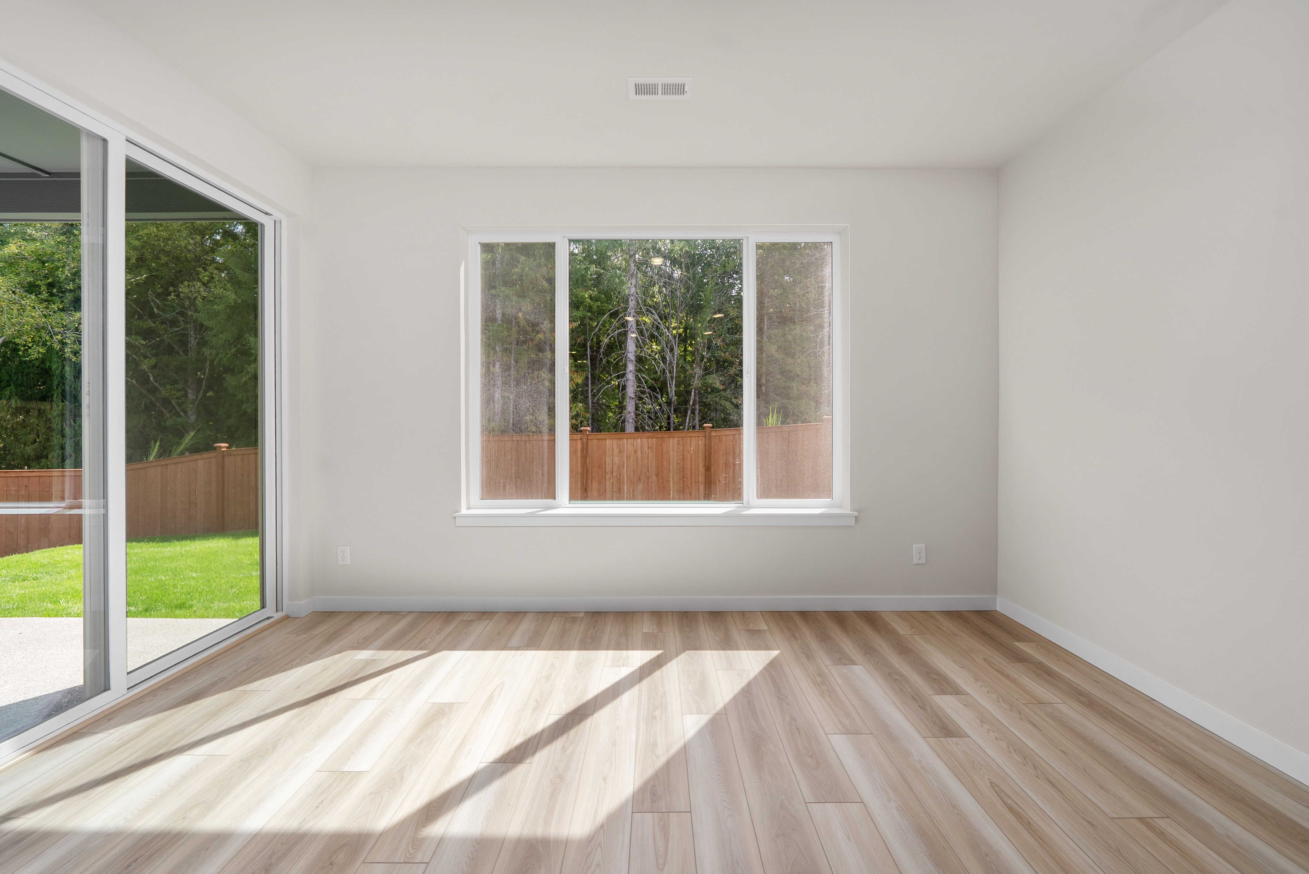 A room with a wood floor and windows.