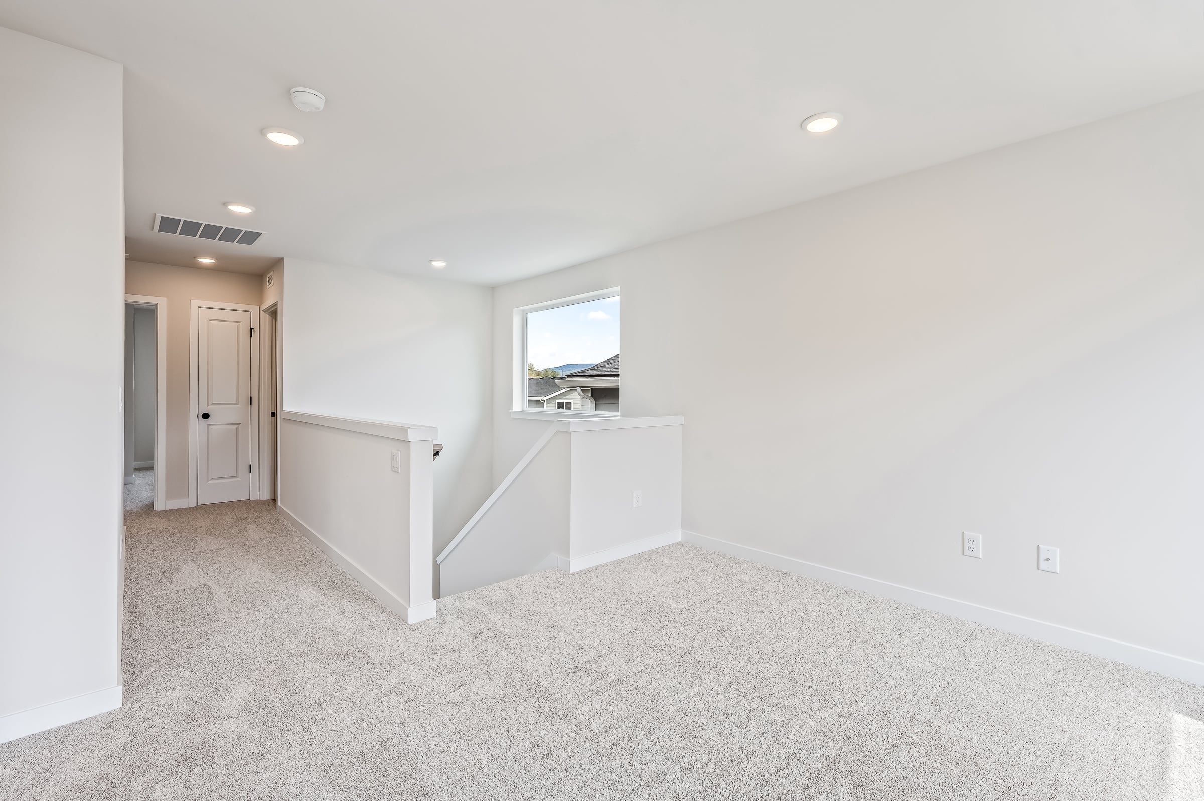 A room with white walls and a tv on the wall.