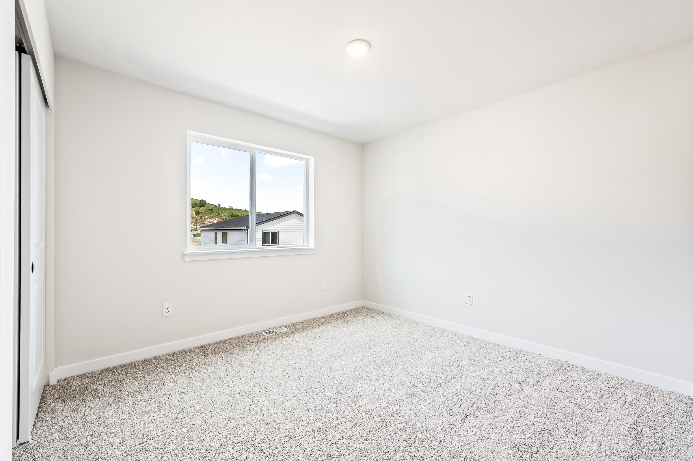 A room with a window and a carpet.