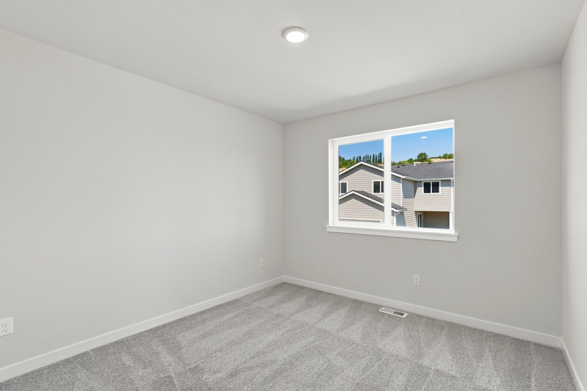 A room with a window and a carpet.