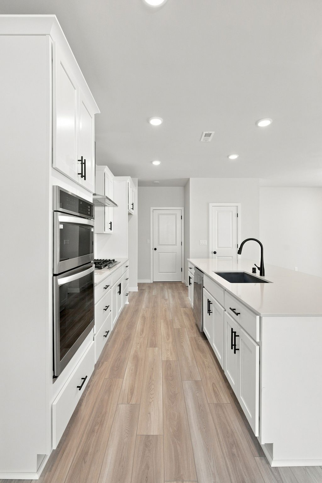 A kitchen with white cabinets.