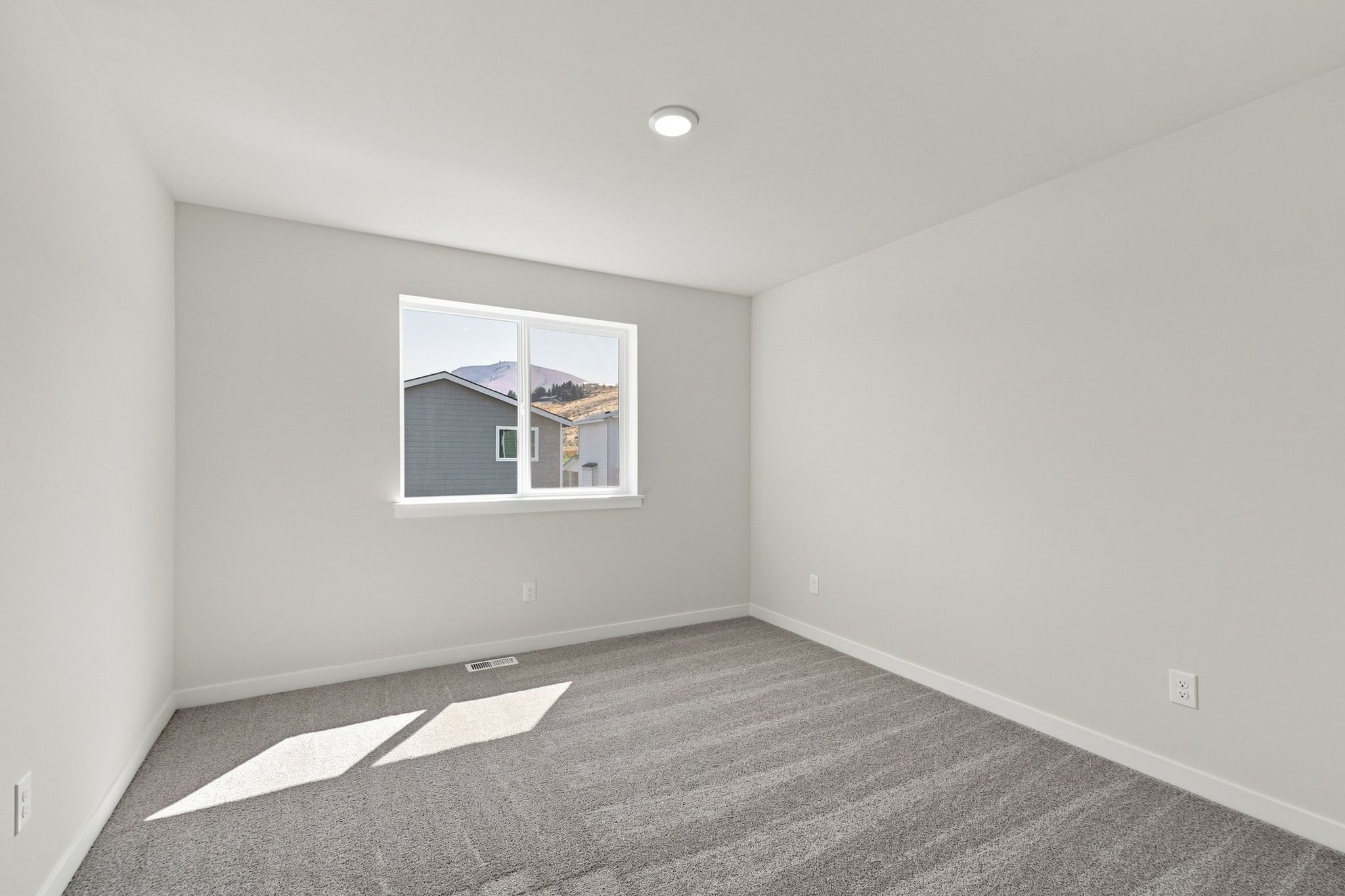 A room with a window and a carpet.