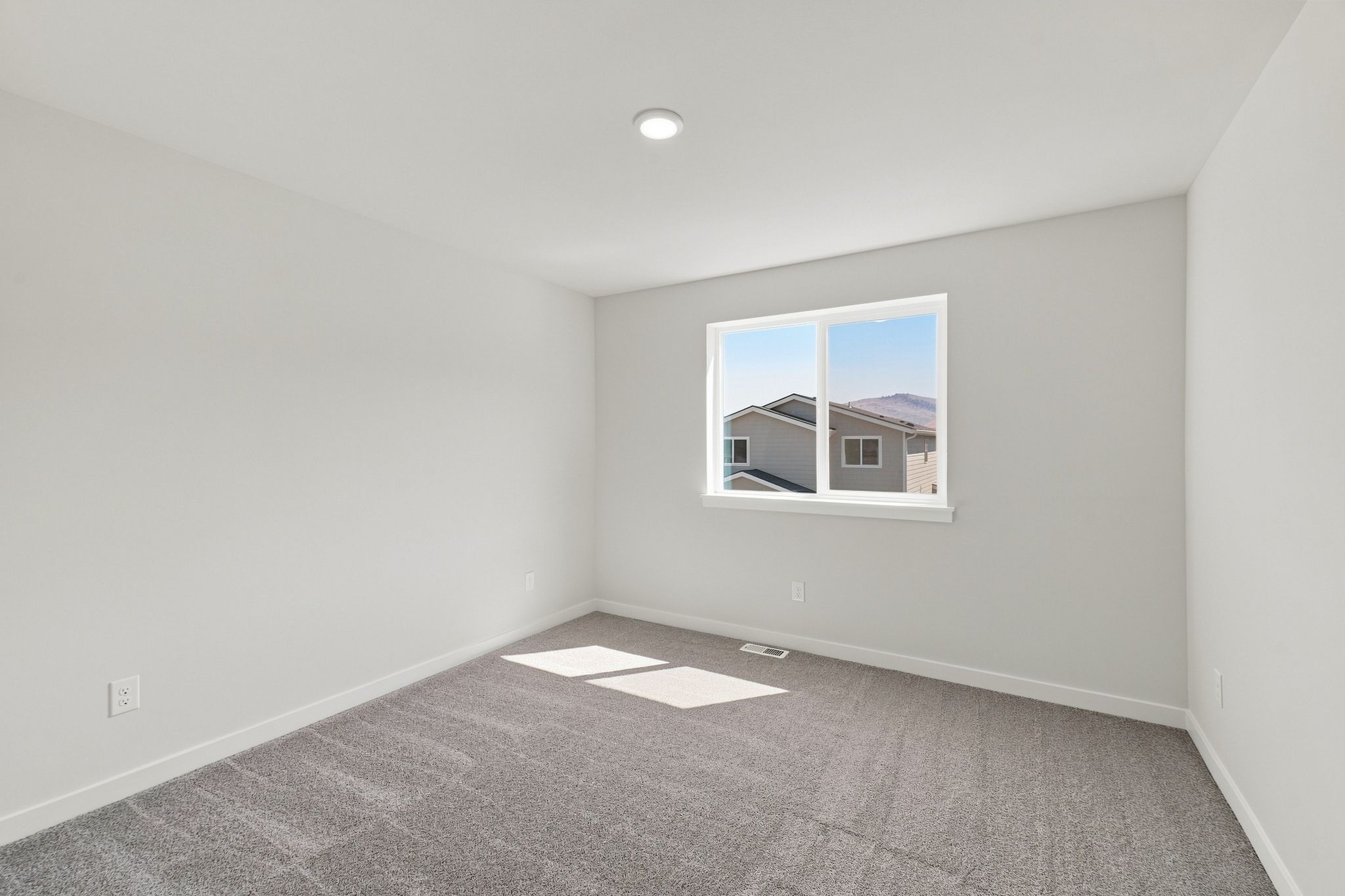 A room with a window and a carpet.