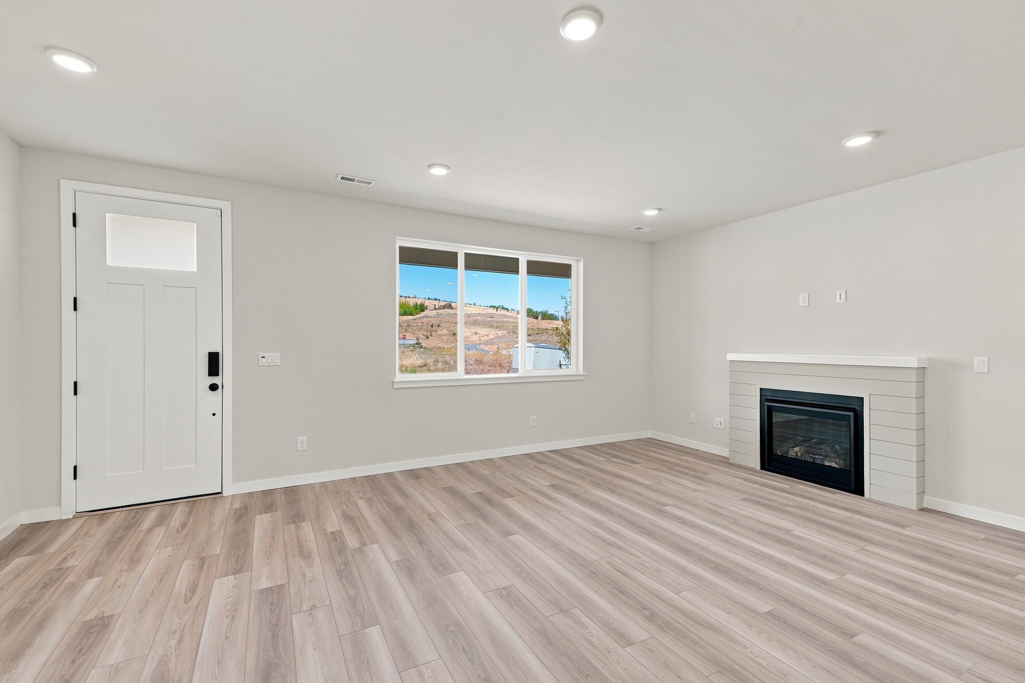 A room with a fireplace and a wood floor.