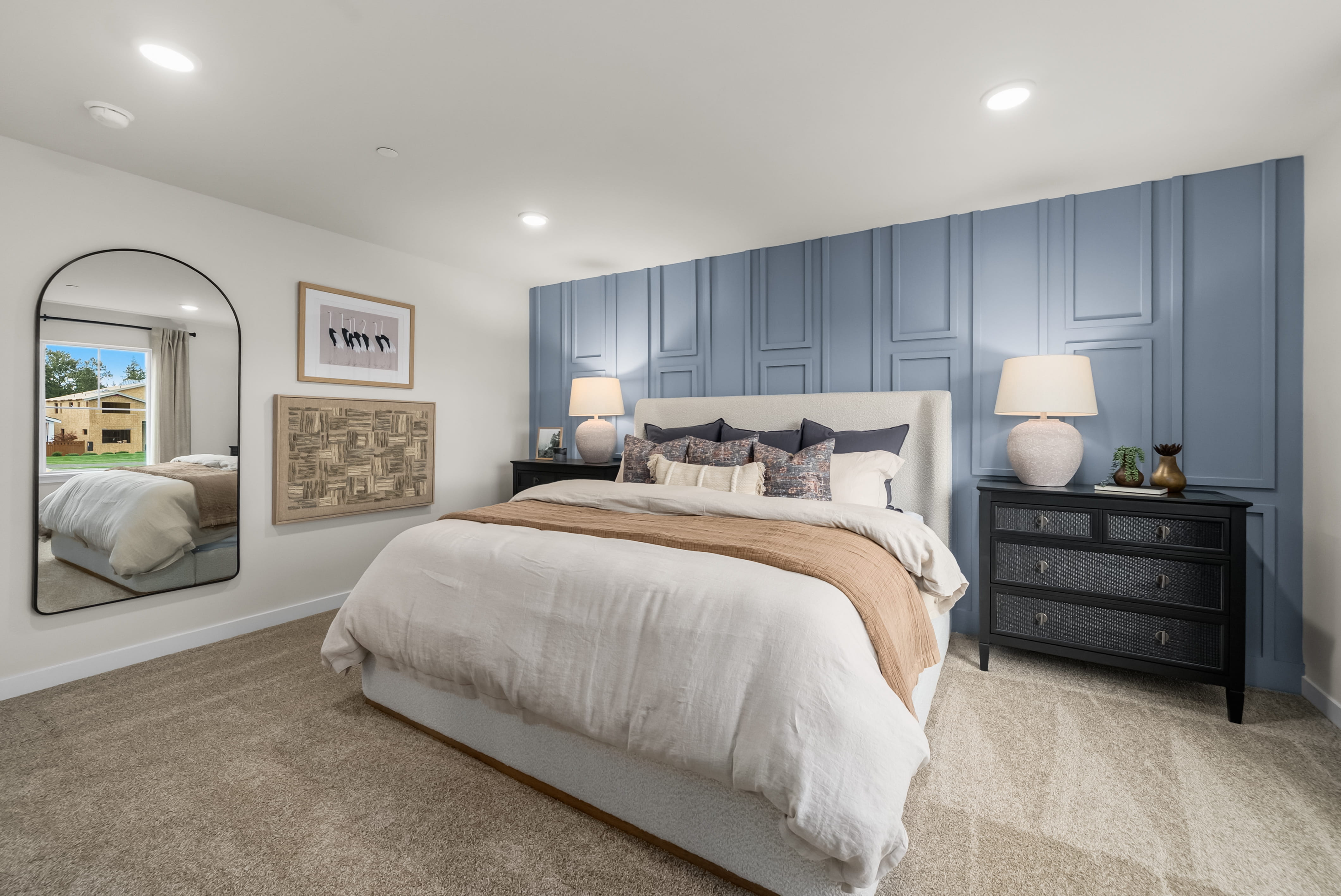 A bedroom with a large mirror.