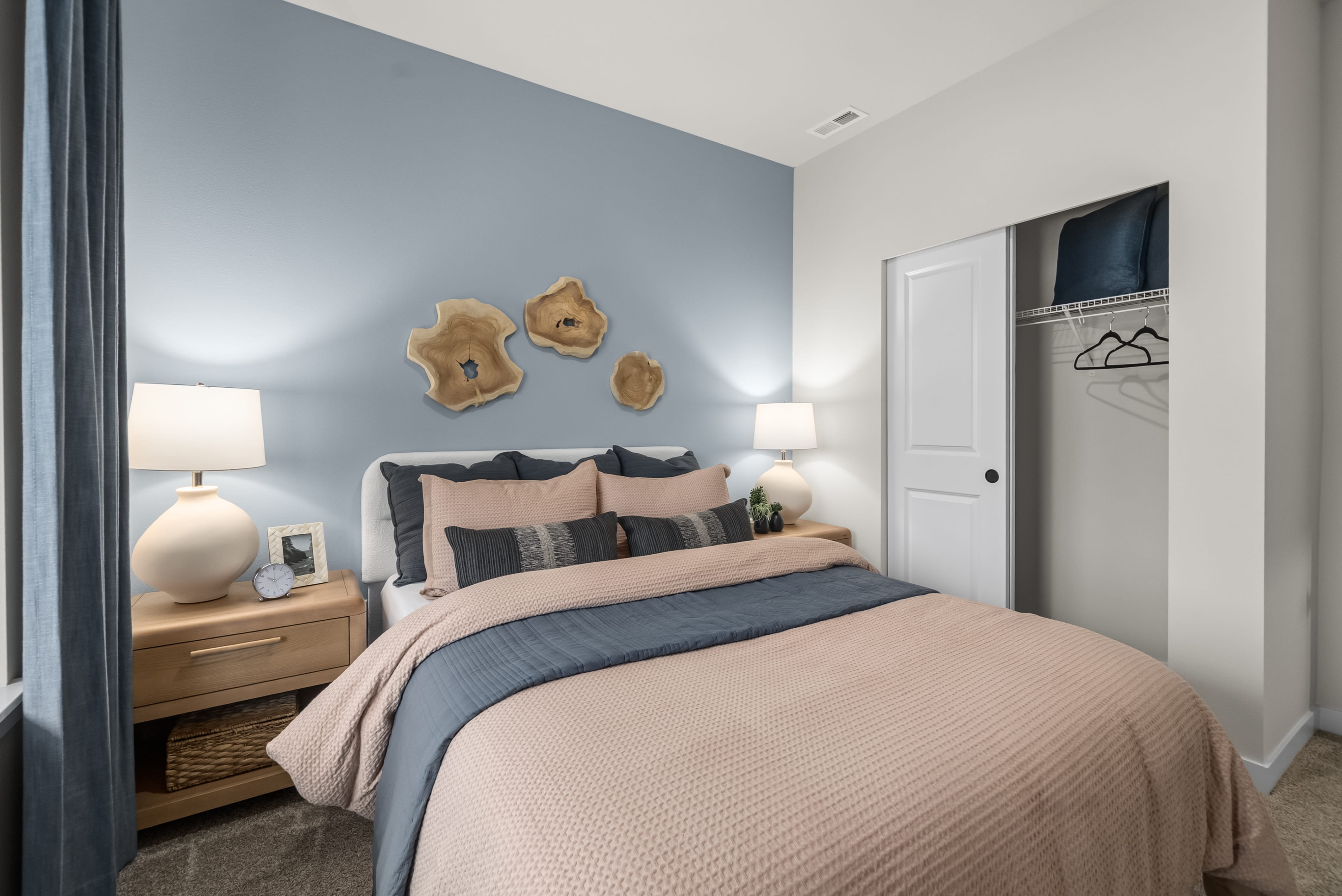 A bedroom with a bed and a lamp.