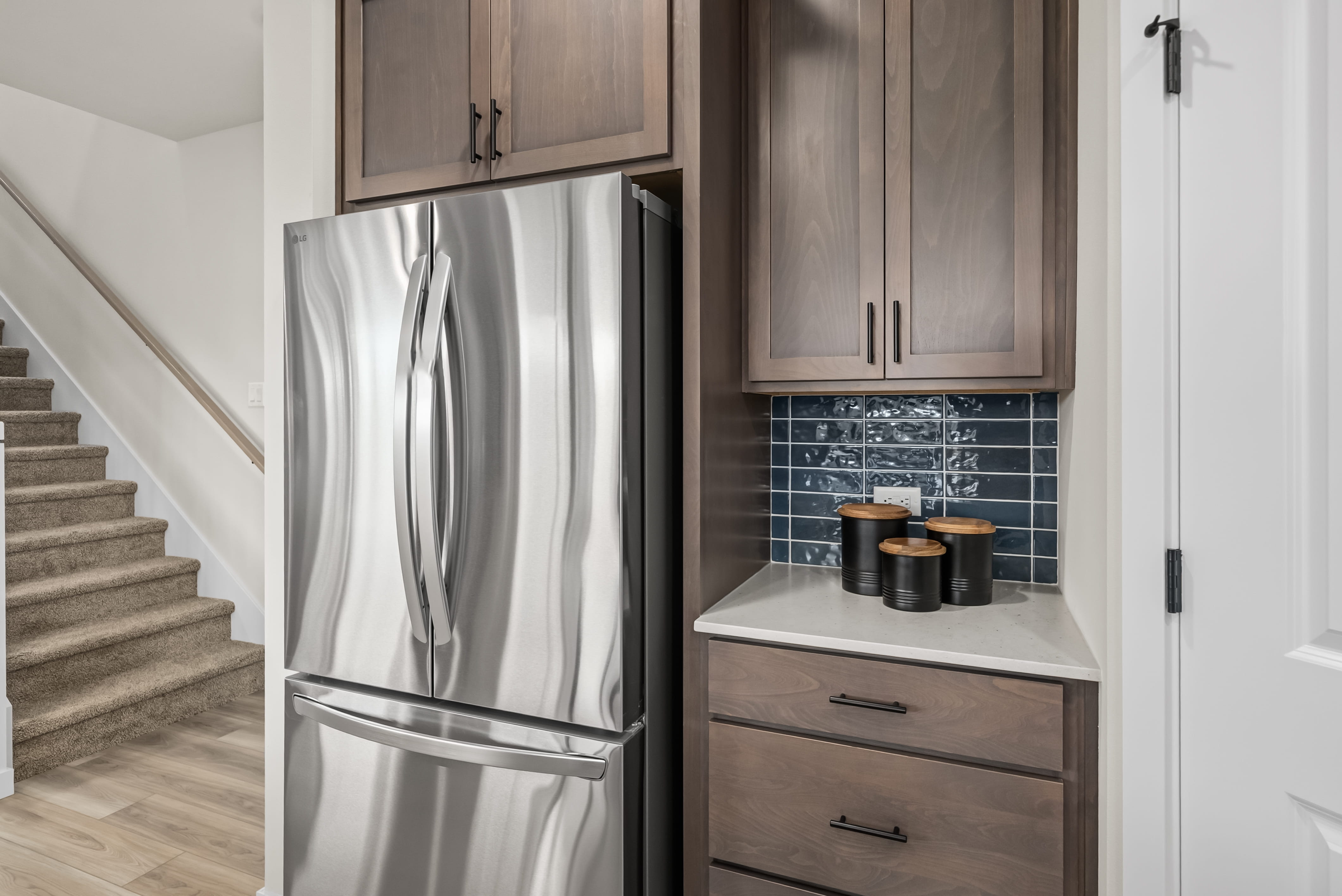 A kitchen with a refrigerator and cabinets.