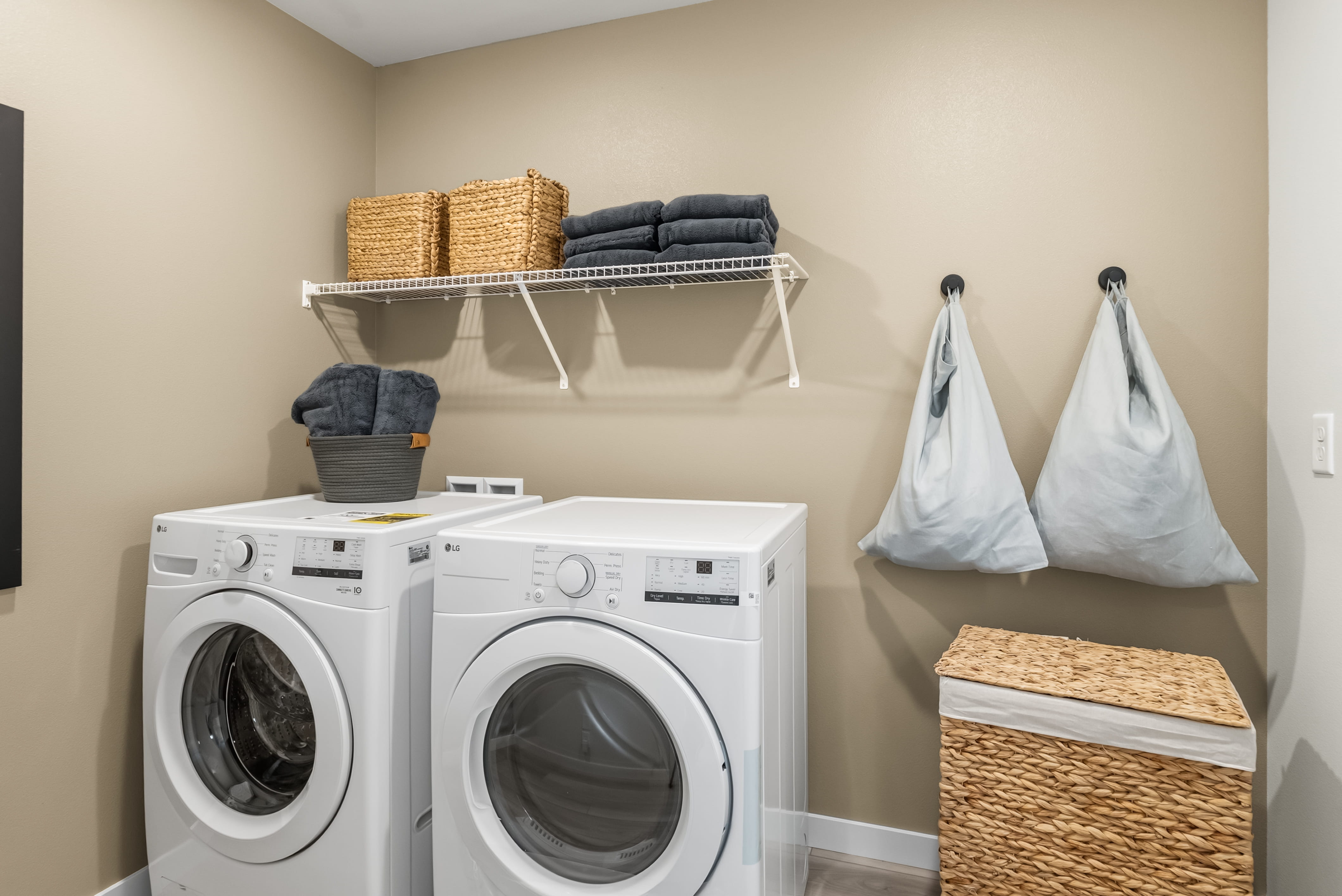A laundry room with a washing machine and laundry basket.