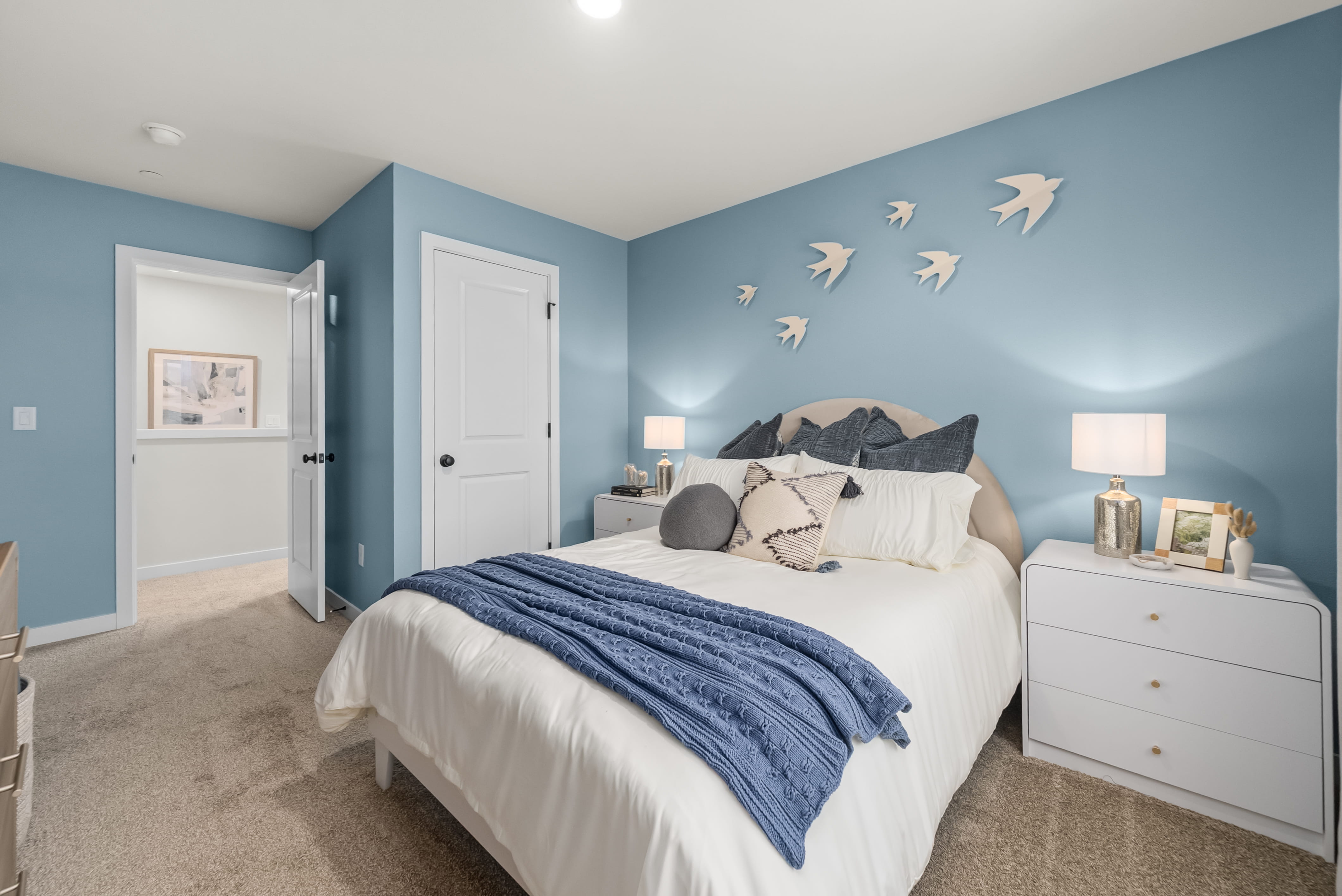 A bedroom with a bed and a blue wall.