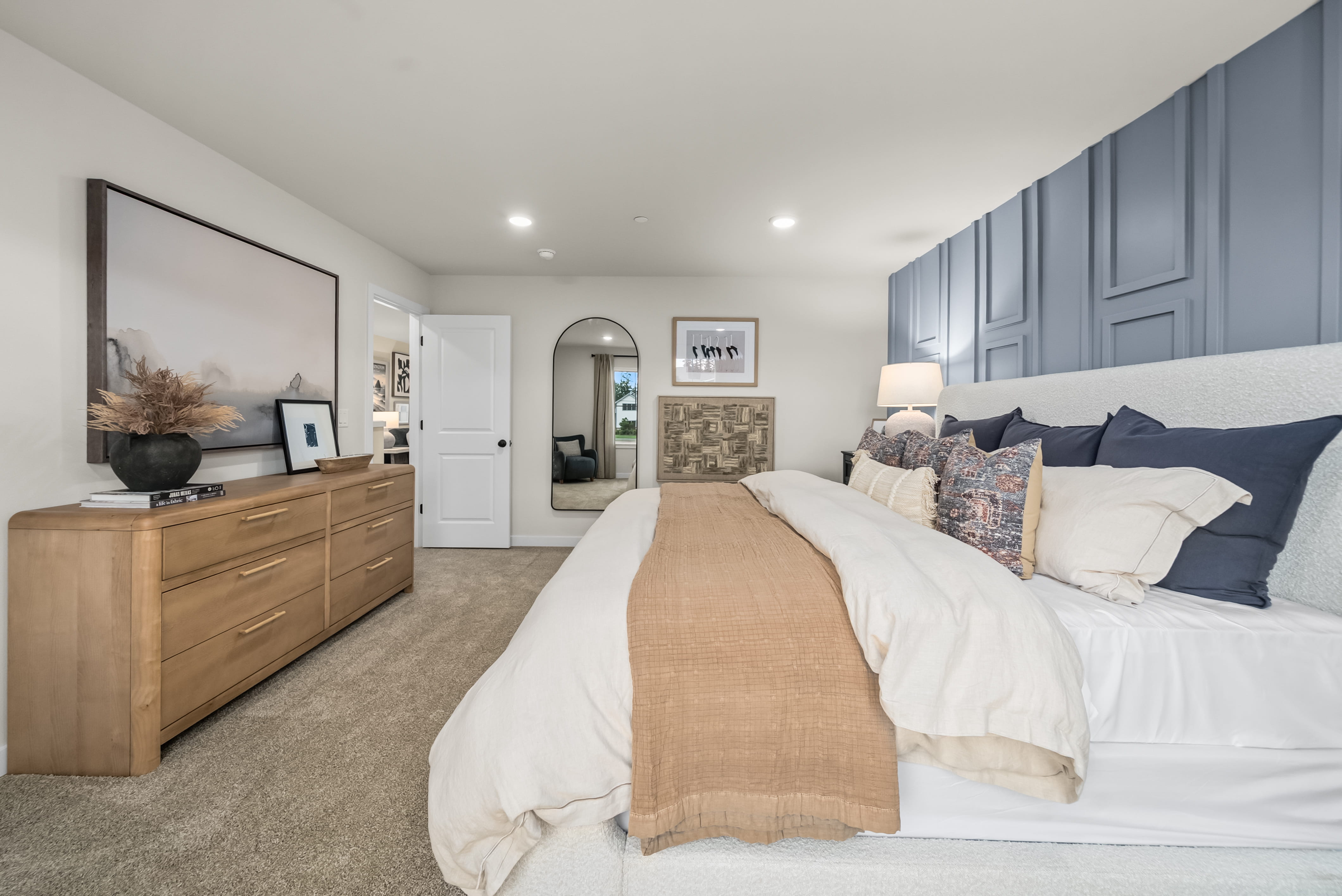 A bedroom with a bed and dresser.
