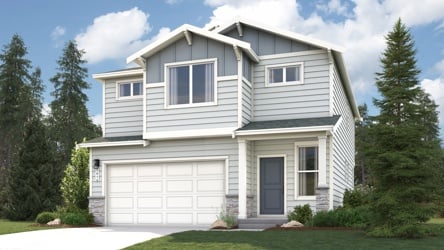 A house with a garage and trees around it.
