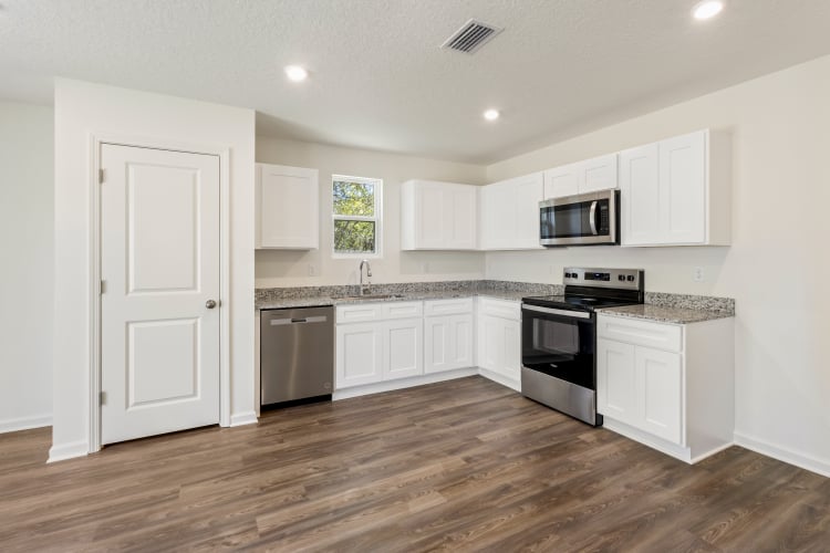 A kitchen with white cabinets.