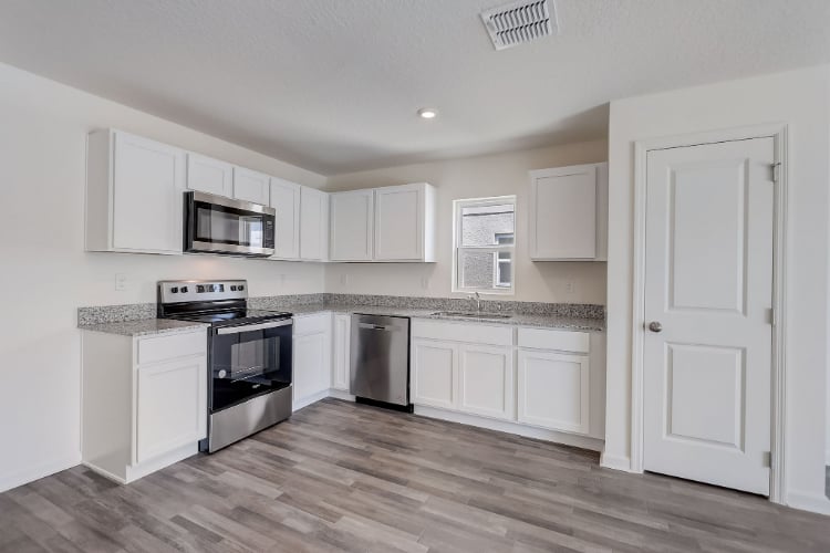 A kitchen with white cabinets.